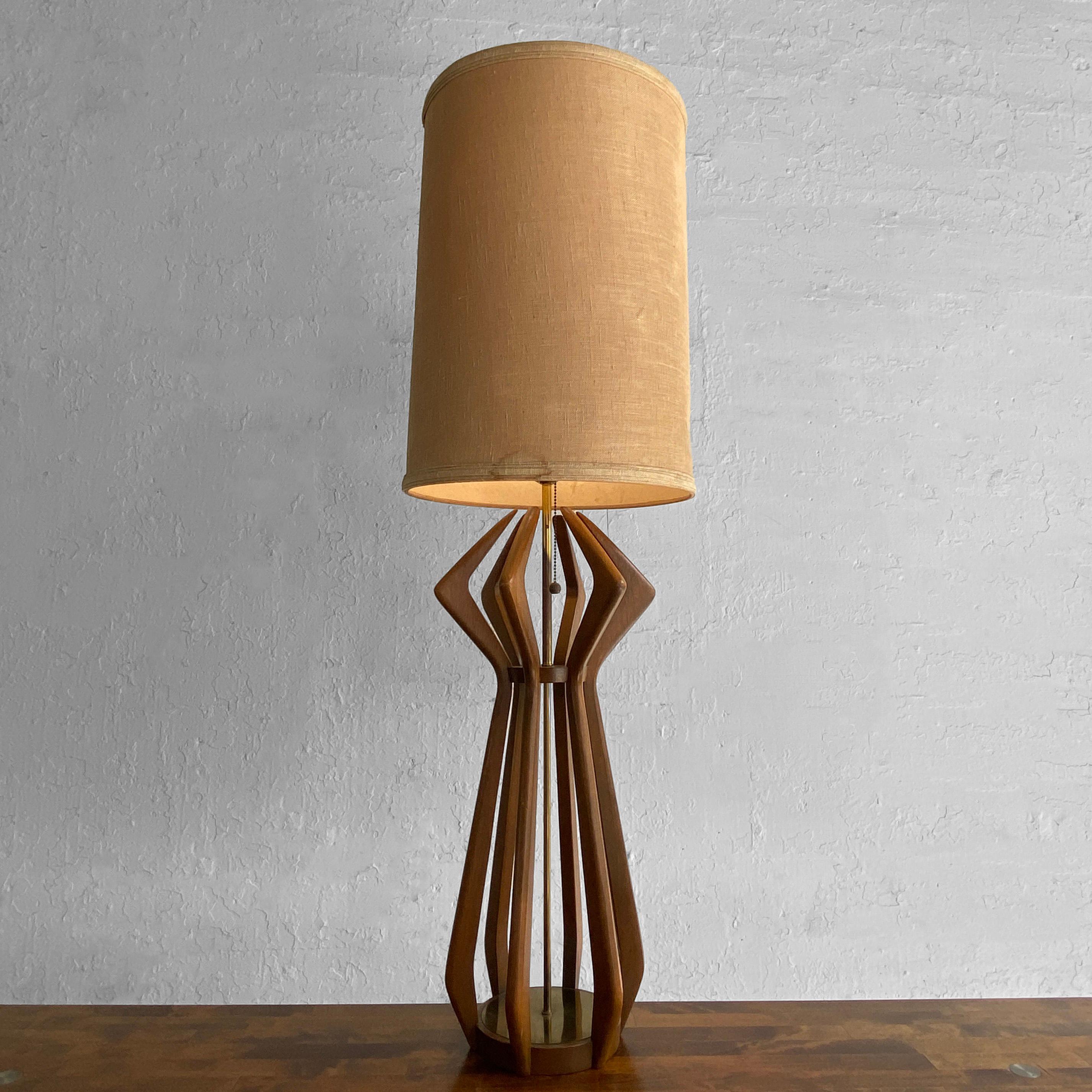 Statuesque, Mid-Century Modern table lamp by Modeline features a segmented, sculptural walnut body with brass accents reminiscent of Adrian Pearsall's work.