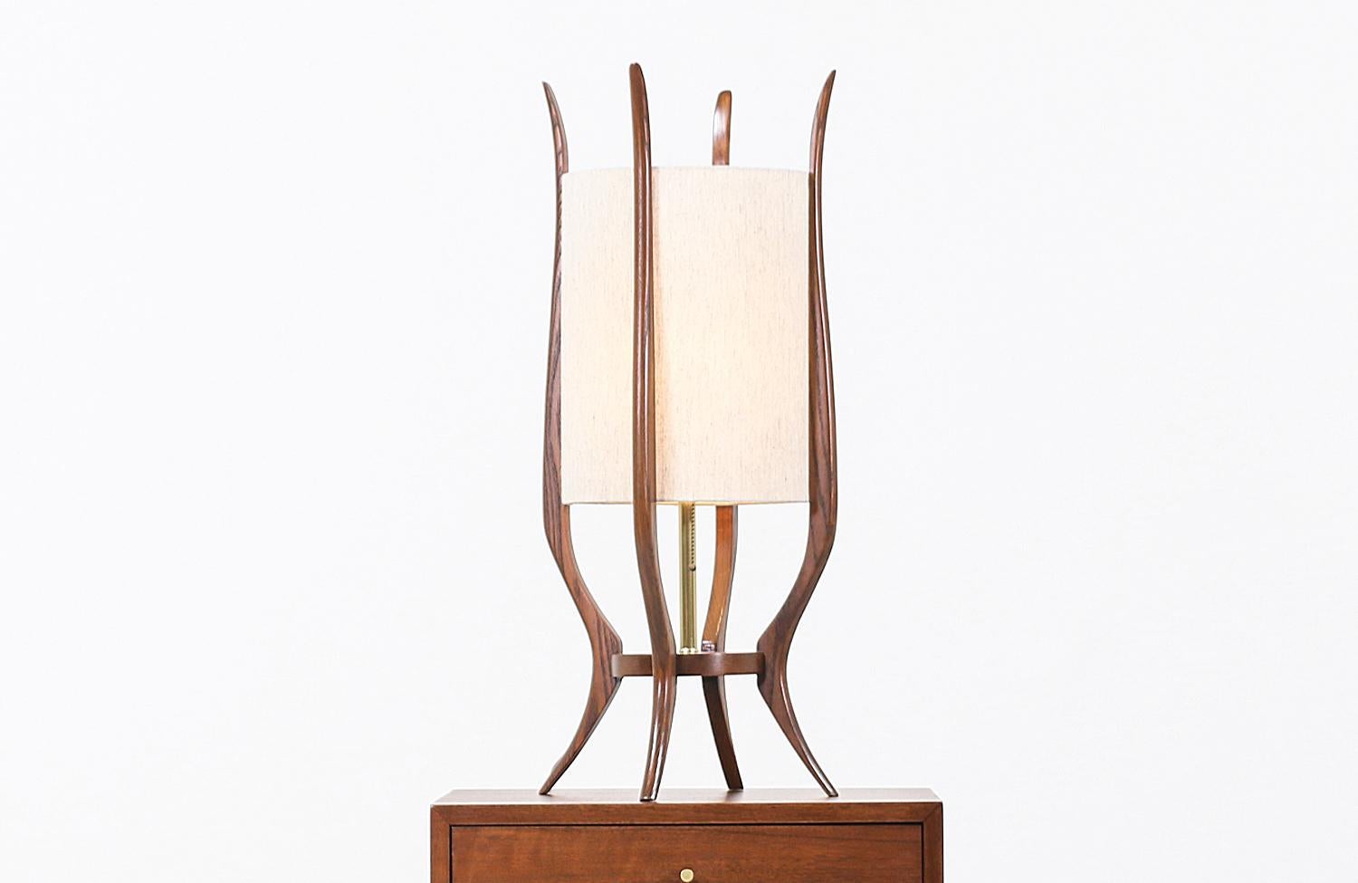 Stylish modern table lamp designed and manufactured by Modeline of California in the United States circa 1960s. This beautiful and sculptural table lamp features an asymmetric walnut wood body with four slim prongs and elegant polished brass