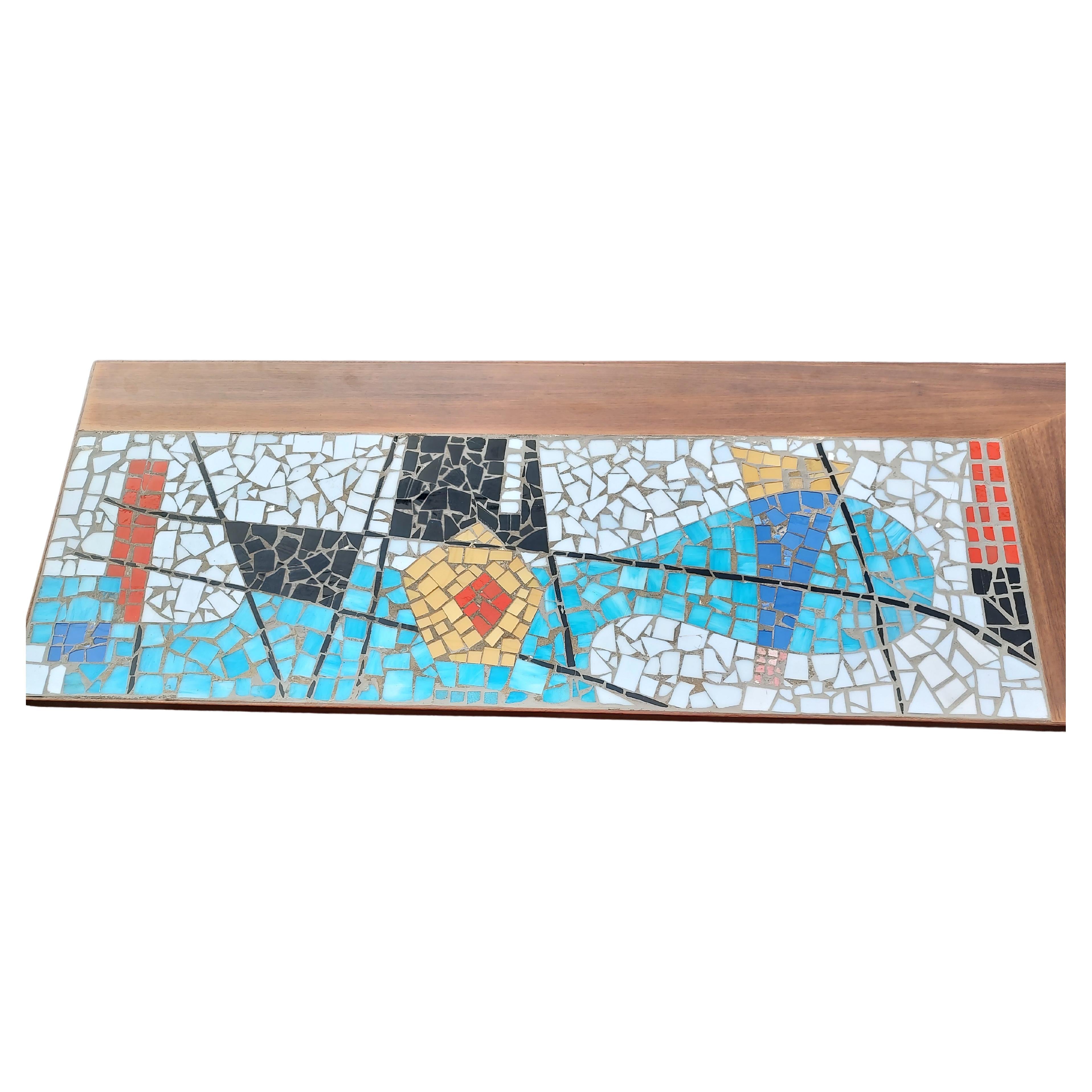 Favoloso tavolo da cocktail a mosaico di metà secolo con piastrelle di vetro colorato e piano in formica. Base in noce con gambe strombate. Misure: 72 pollici x 24 x 14,25H lo rendono un pezzo unico. In eccellenti condizioni di restauro con usura