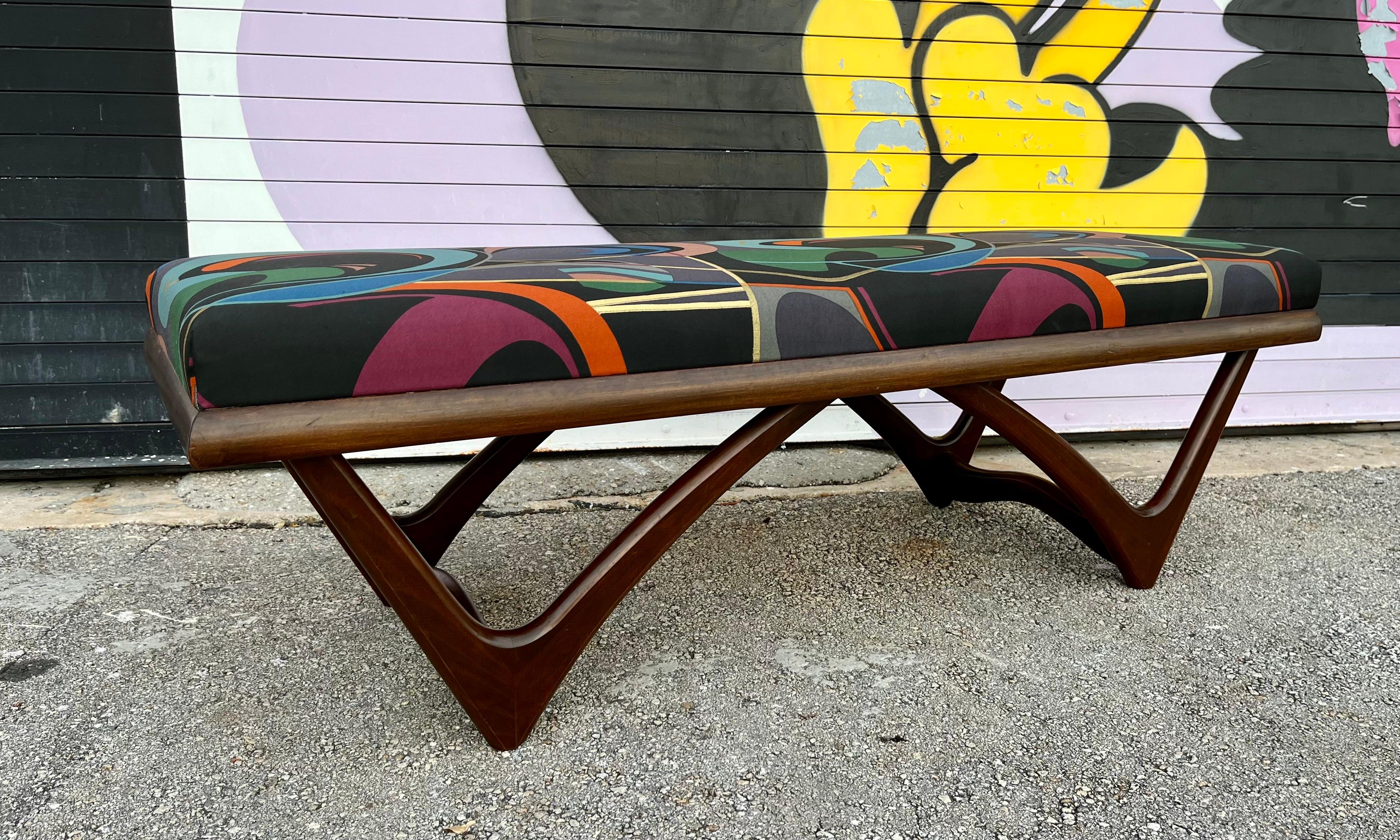 Mid-Century Modern Sculptural Bench in the Adrian Pearsall Style. Circa 1960s.
Features a dark walnut toned wood base with boomerang shaped legs and a newly reupholstered cushion with a vintage optical print fabric. 
In excellent original condition