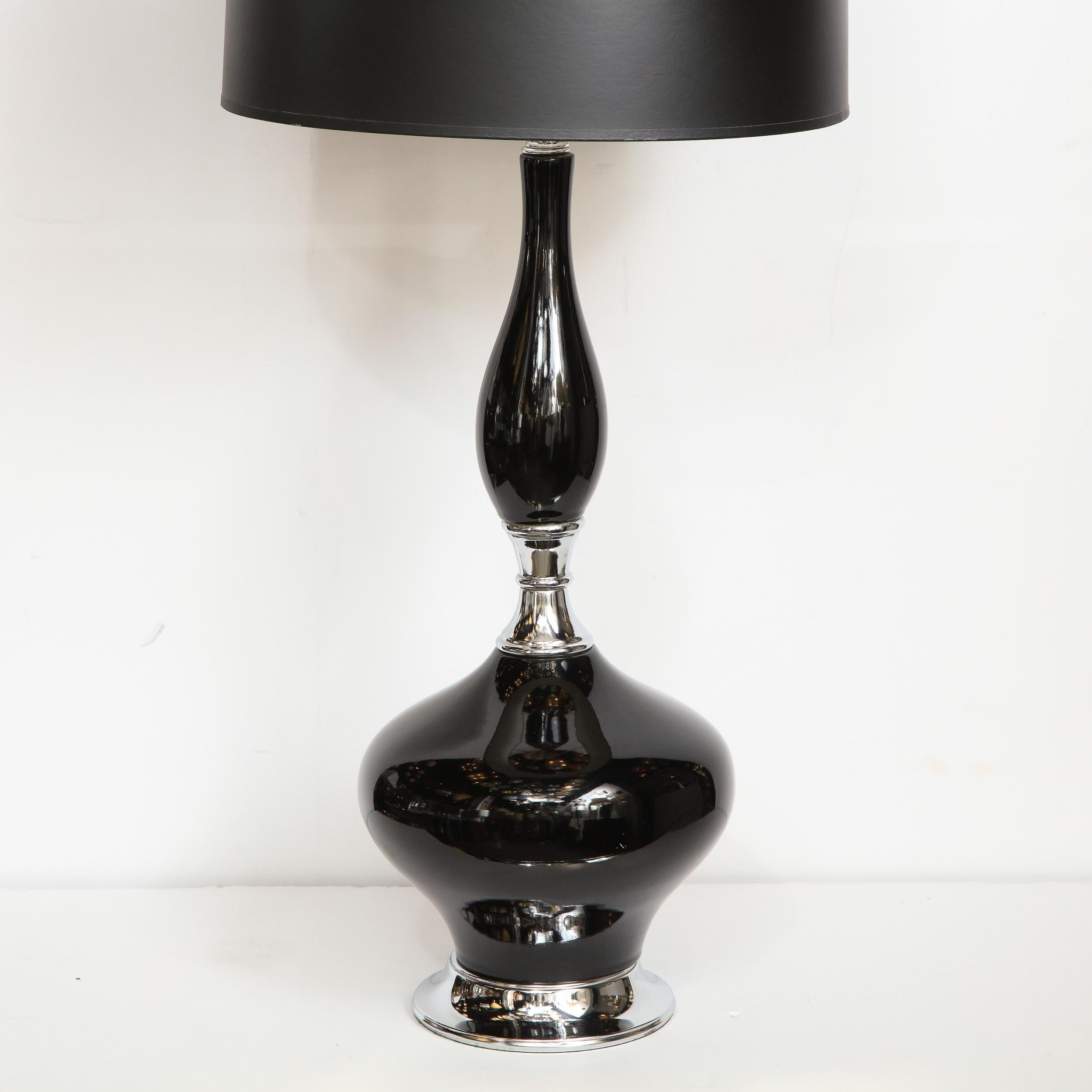 This beautiful Mid-Century Modern ceramic lamp was realized in the United States, circa 1960. It features an organic protuberant form finished in a lustrous black glaze that extends upwards from a chrome base. Elegant, whimsical and dramatic, this