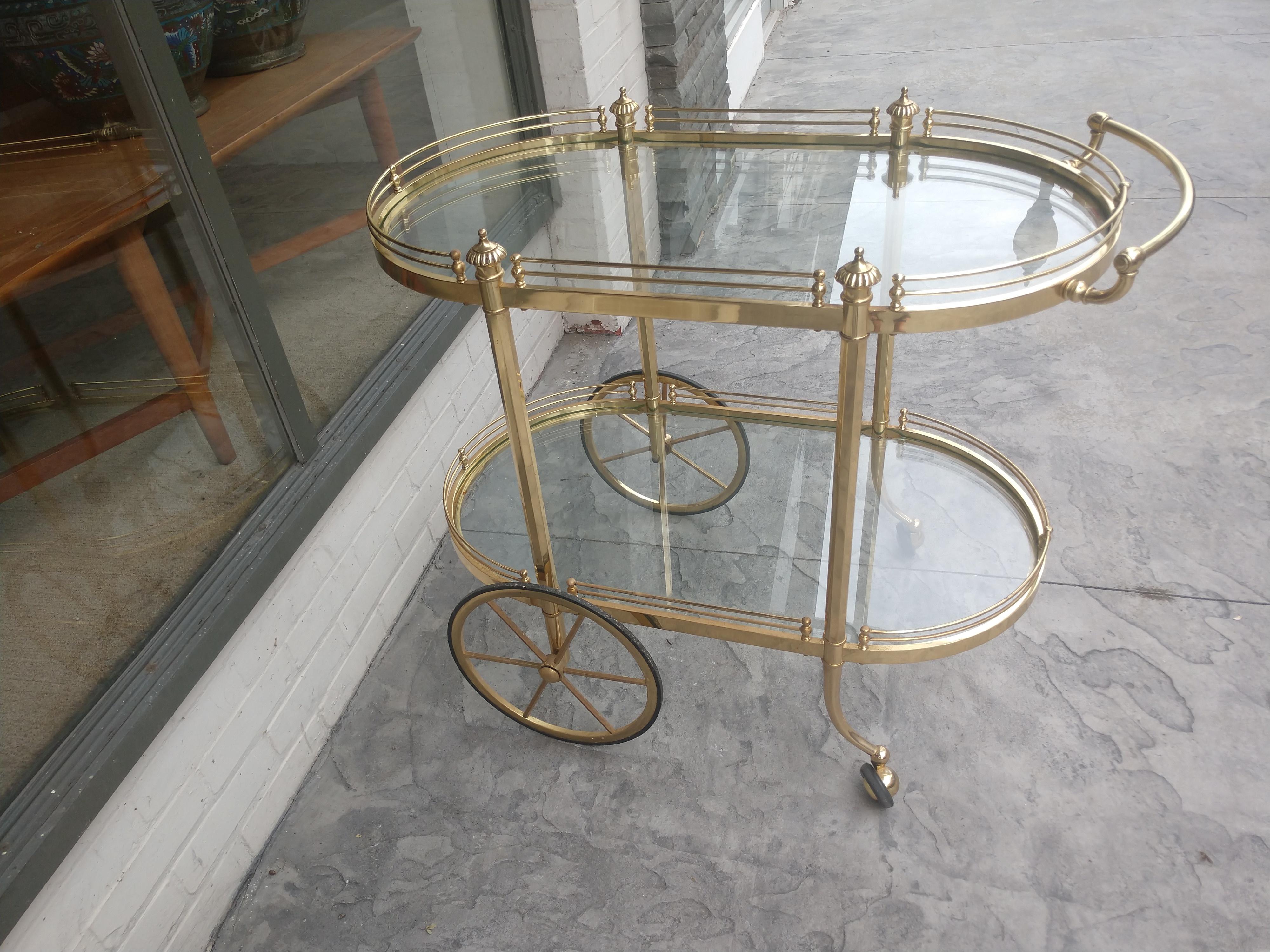 Elliptical in shape with two tiers surrounded by a gallery. Glass is perfect. Cart glides along. Brass retains original patina.l