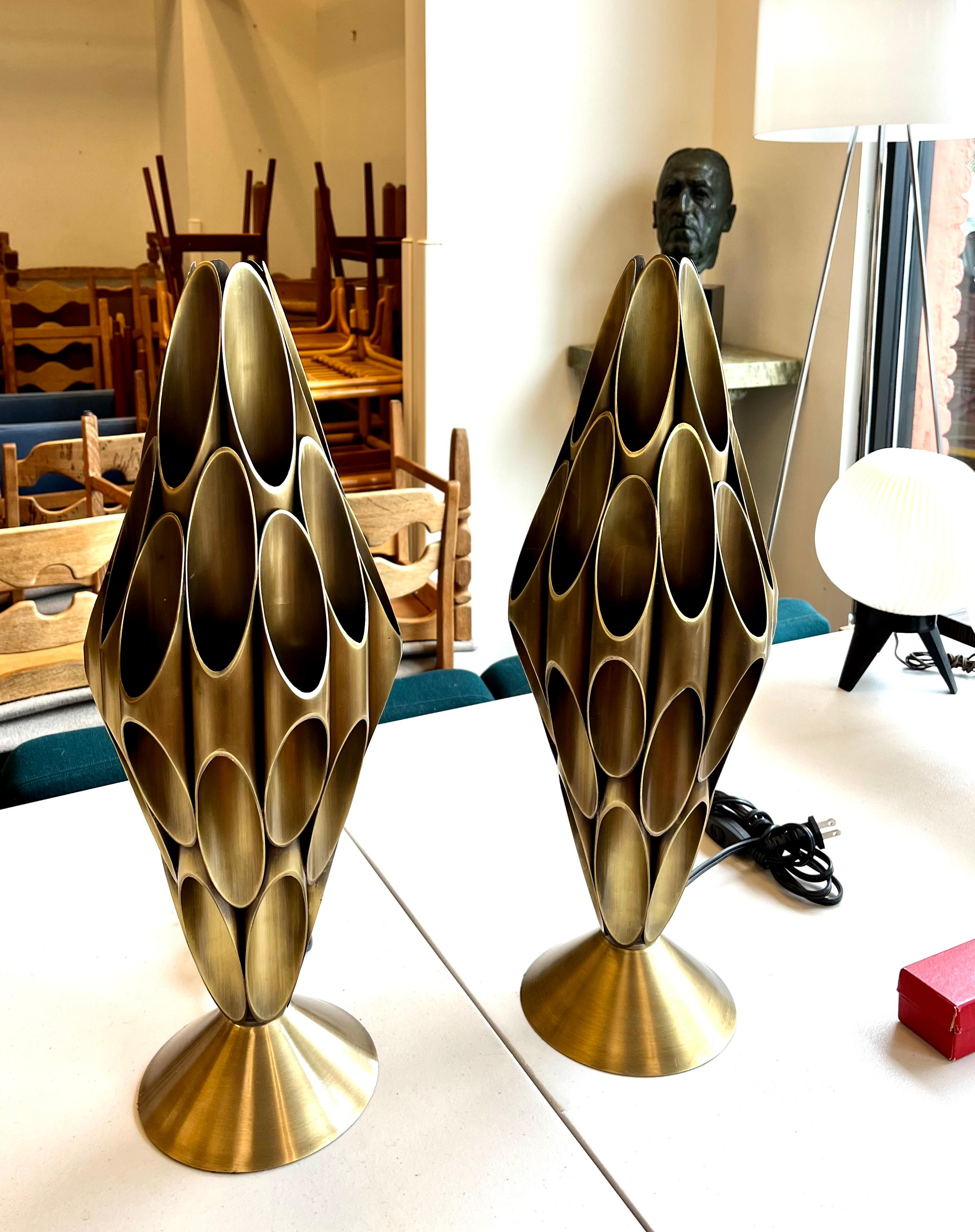 Eye catching mid century modern lamps that are really pieces of art.  They are sculptural heavy tubular brushed brass in the manner of Roger Rougier, but unmarked. 