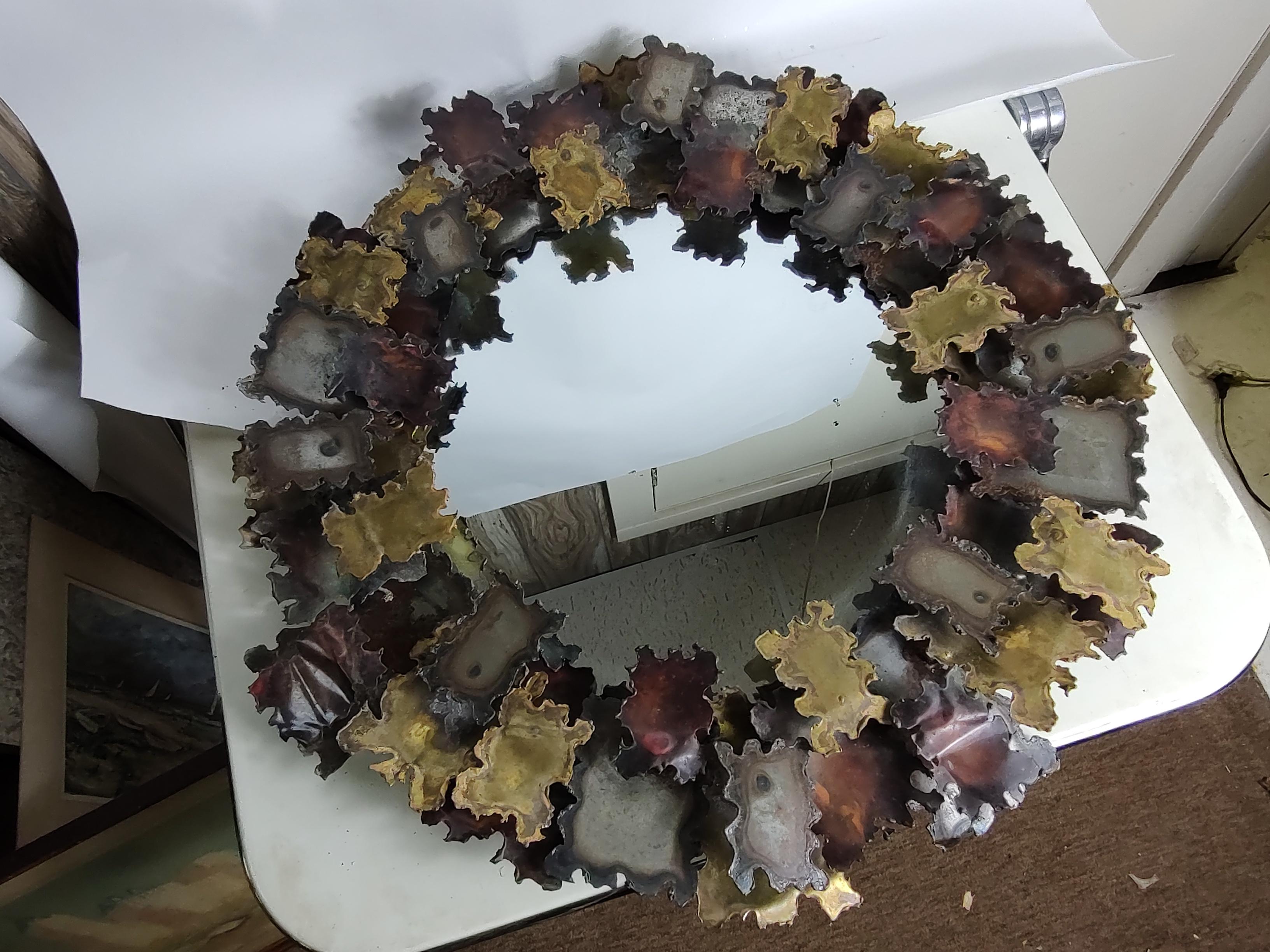 Fabulous torch cut and welded brutalist mirror possibly by Curtis Jere. Copper Brass and Steel cut pieces assembled and surrounding the mirror reminiscint of fall leaves. In excellent vintage condition with minimal wear. Can be parcel posted.