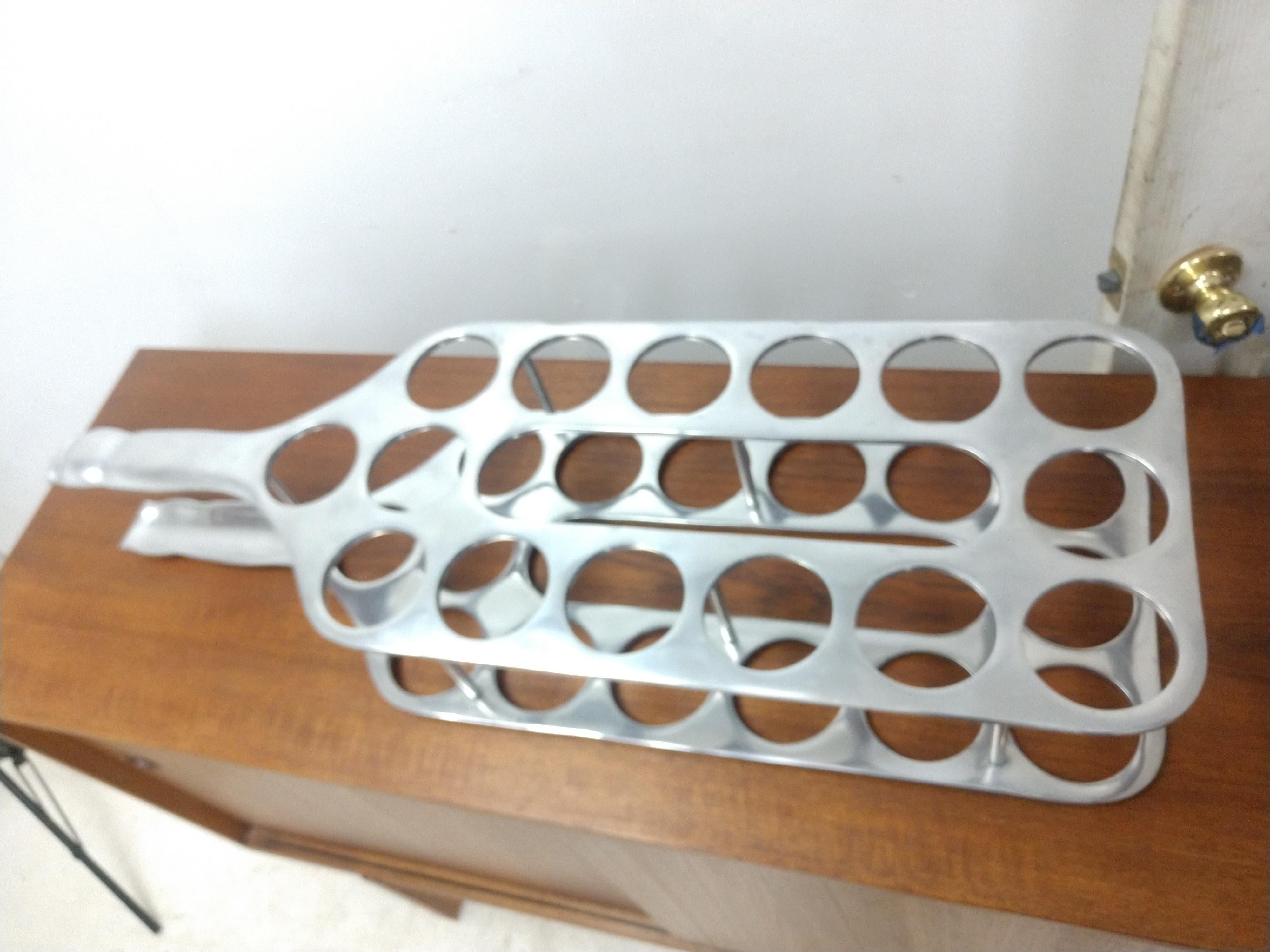 Simple, elegant and playful in the shape of a tall bottle. This cast aluminum wine rack can sit on the floor or on the bar. Holds 15 bottles of your favorites. This item can be parcel posted inexpensively.