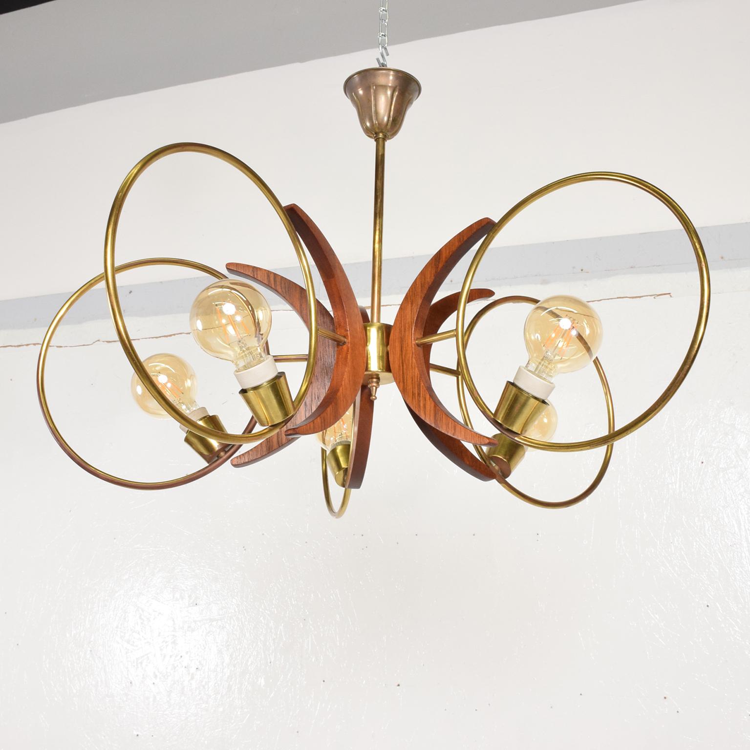Modern Five Ring Swirling Sculptural Chandelier from Mexico City 1960s
Unmarked. Crisp Clean design.
Features five rings in patinated brass with sculptural mahogany wood ornamentation.
Dimensions 33 in diameter x 22 tall inches.
Vintage patina on