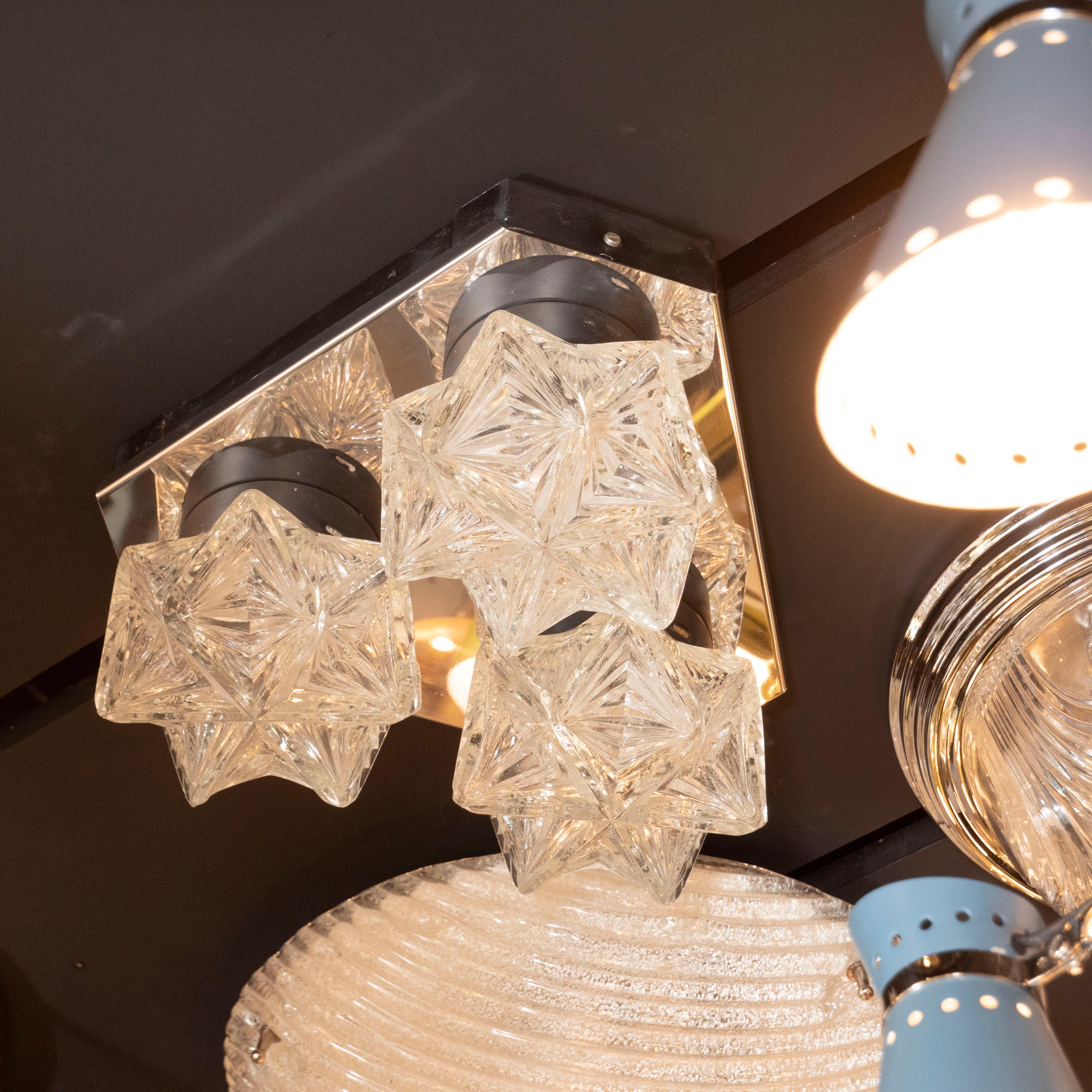 This sculptural flush mount was realized in Germany, circa 1950. It features three hand blown hexagonal translucent faceted glass shades offering an abundance of geometric angular forms in relief. The shades attach to a hexagonal base in polished