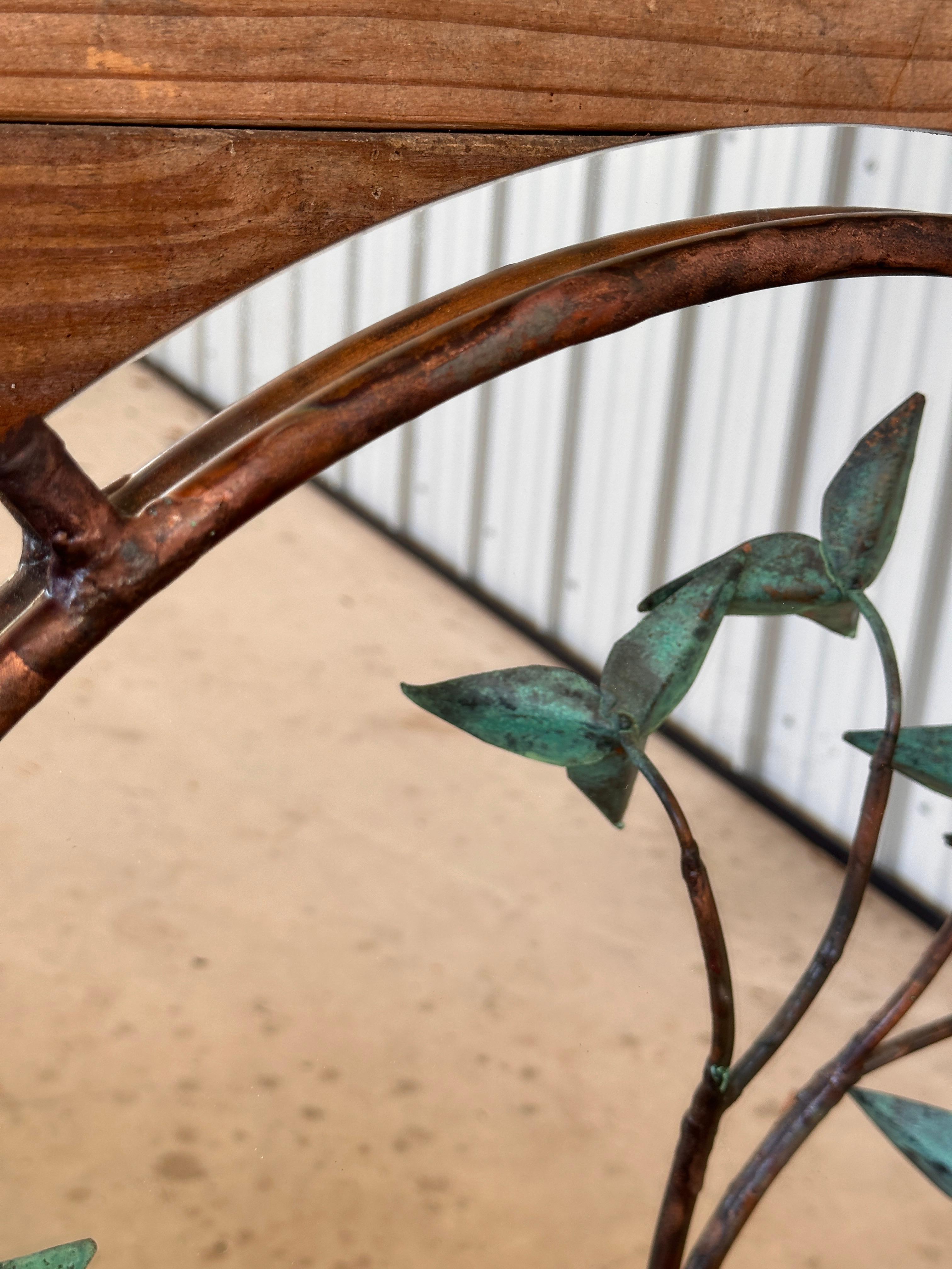 Imperfections and tarnish to the copper and minor scuffs to mirror.
DescriptionThis striking Mid-Century Modern wall mirror features a sculptural design with a forged copper frame and intricate verdigris foliage. The botanical-inspired accents