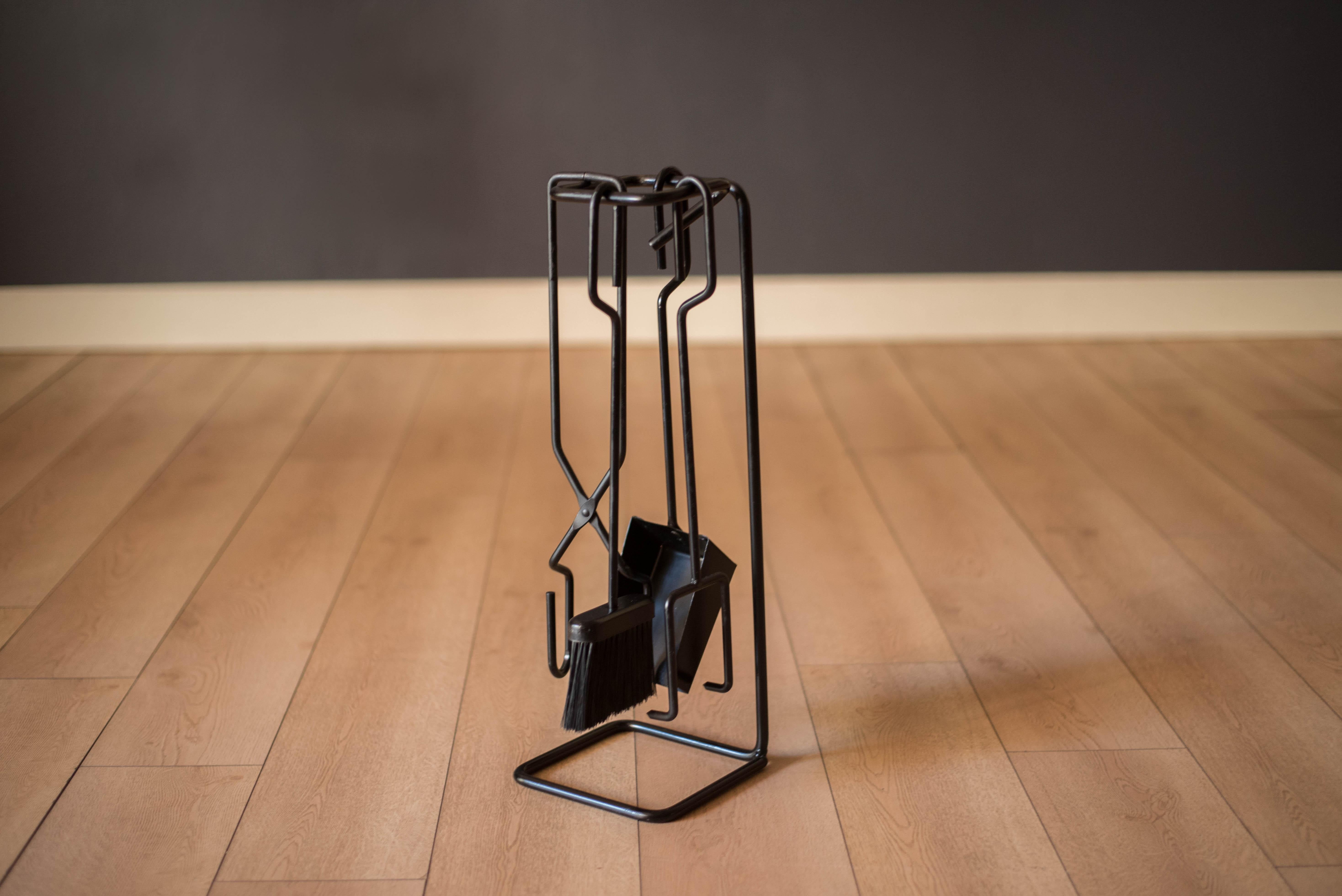 Juego de herramientas vintage de 4 piezas para chimenea, de hierro fundido y forjado, hacia la década de 1970. Este conjunto único presenta un diseño escultural e incluye una pala, un cepillo, un atizador y unas pinzas con soporte de suelo lastrado. 