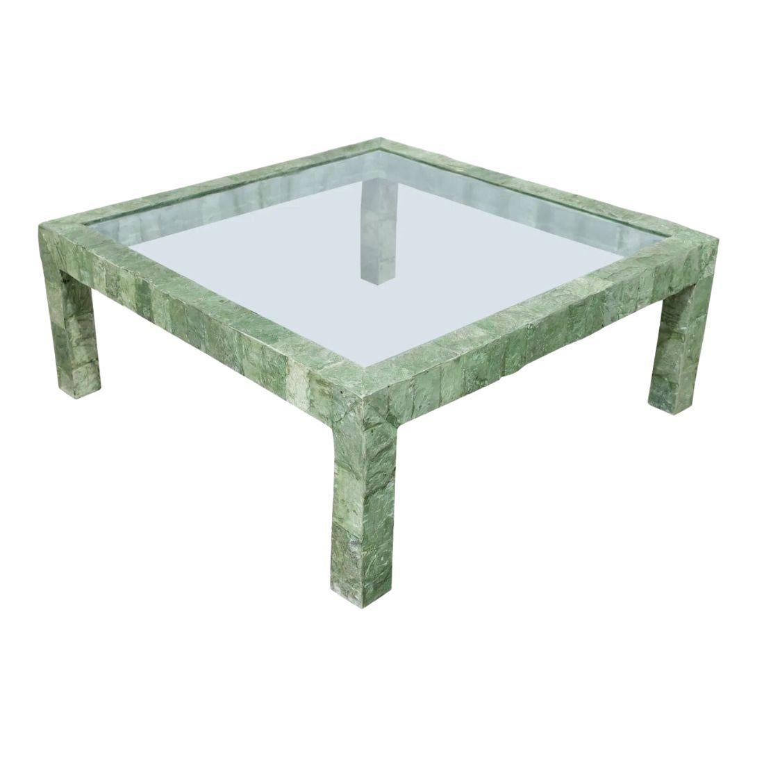 Table basse verte sculpturale du milieu du siècle avec un plateau en verre.  Le cadre en fausse pierre, de composition verte, avec de gros pieds carrés, entoure le plateau en verre. 