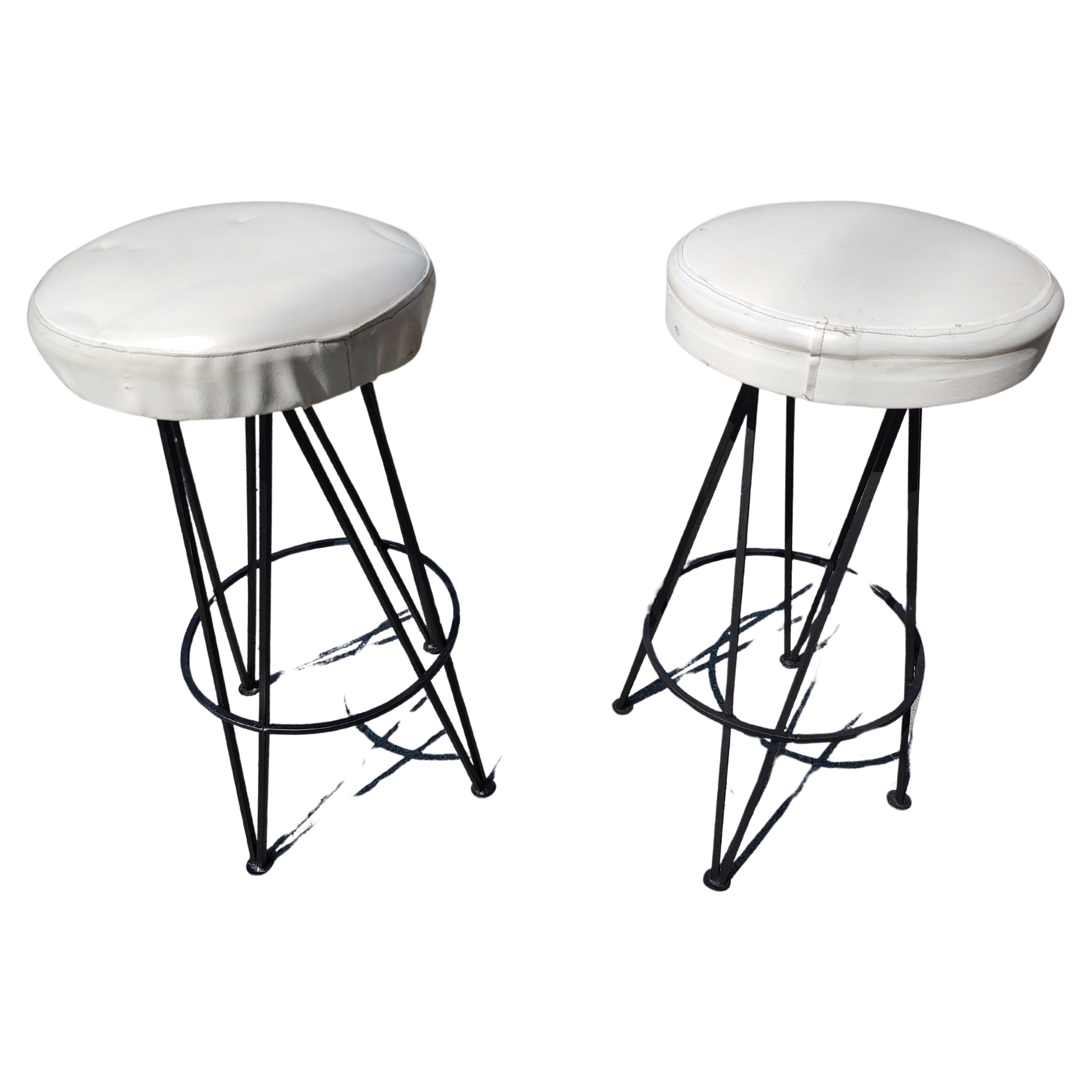 Pryamid shaped iron bases with round swiveling stools atop covered in naugahyde white fabric. A few are dark blue vinyl. Iron has been just been recently sprayed. In excellent vintage condition with minimal wear. Seat covering could use an upgrade.