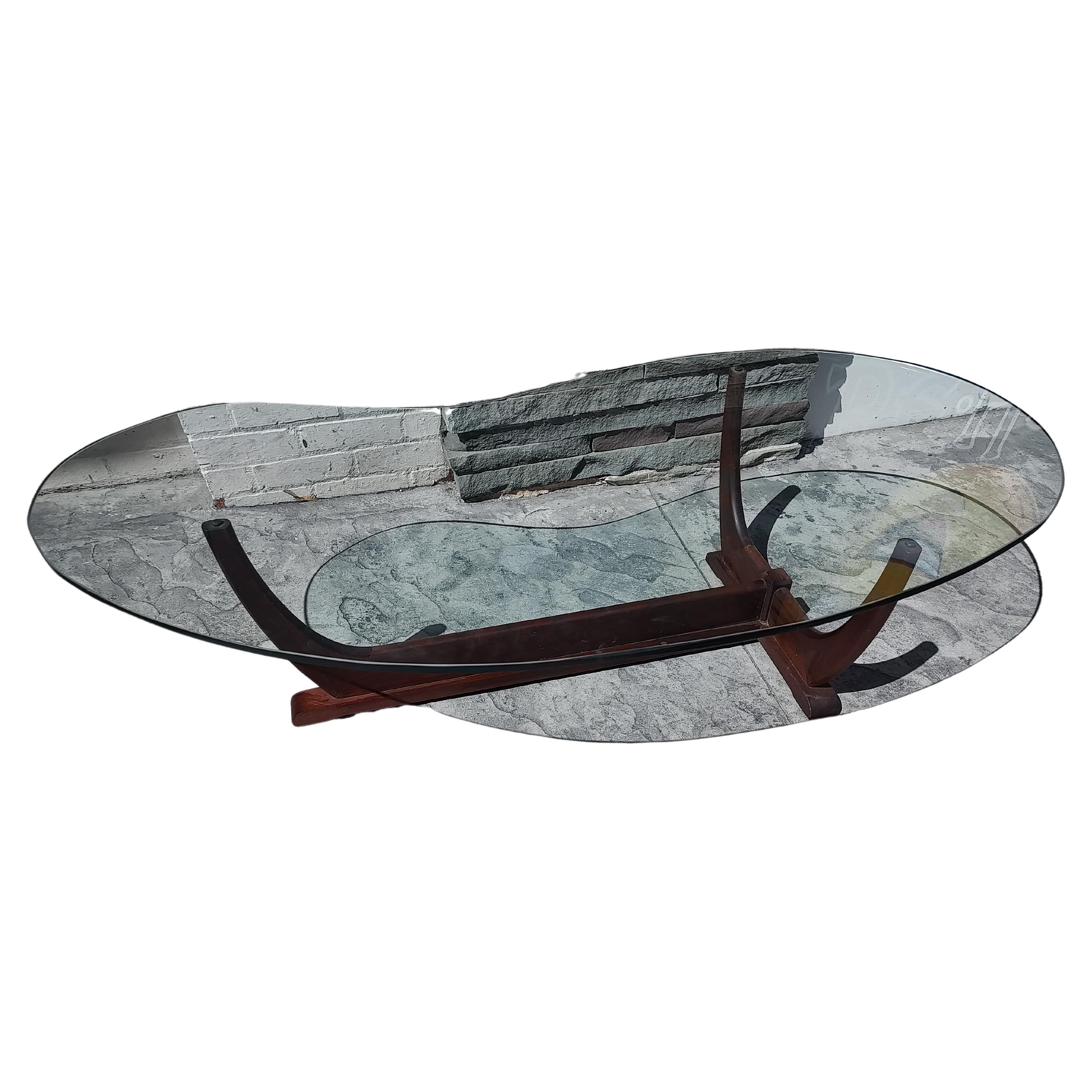 Fabulosa mesa de cóctel en forma de riñón atribuida a Adrian Pearsall & Craft Associates. Pata triangular de nogal que sostiene la tapa de cristal en forma de riñón. En excelente estado vintage con un desgaste mínimo, el cristal está perfecto.