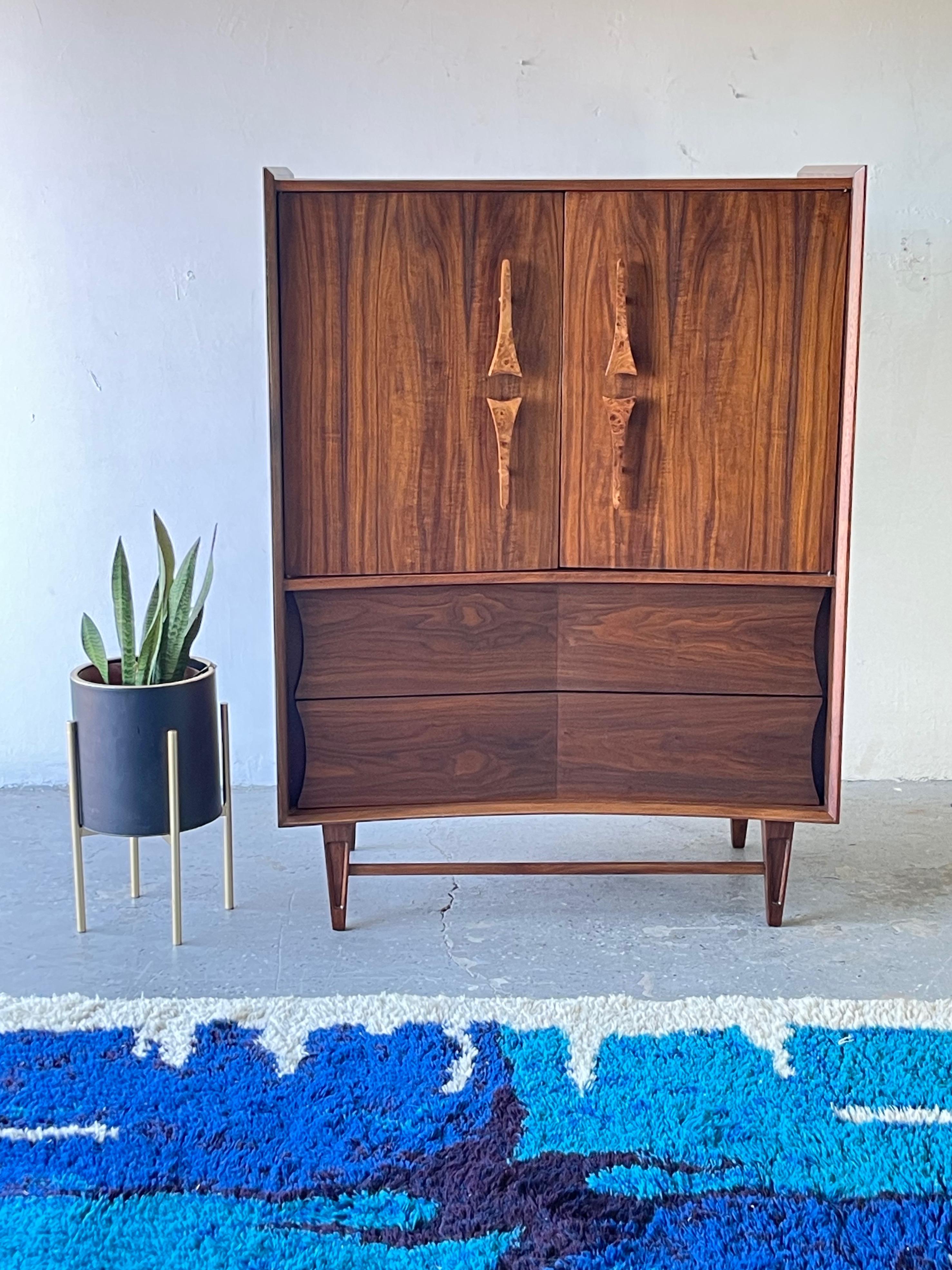 Mid century sculptural dresser or armoireKagan Style
An unbelievably cool and designed by the Genova Furniture Company. This mid century modern armoire / dresser featuring gorgeous carved/ Burl wood sculpted wood handles! It features a bow front