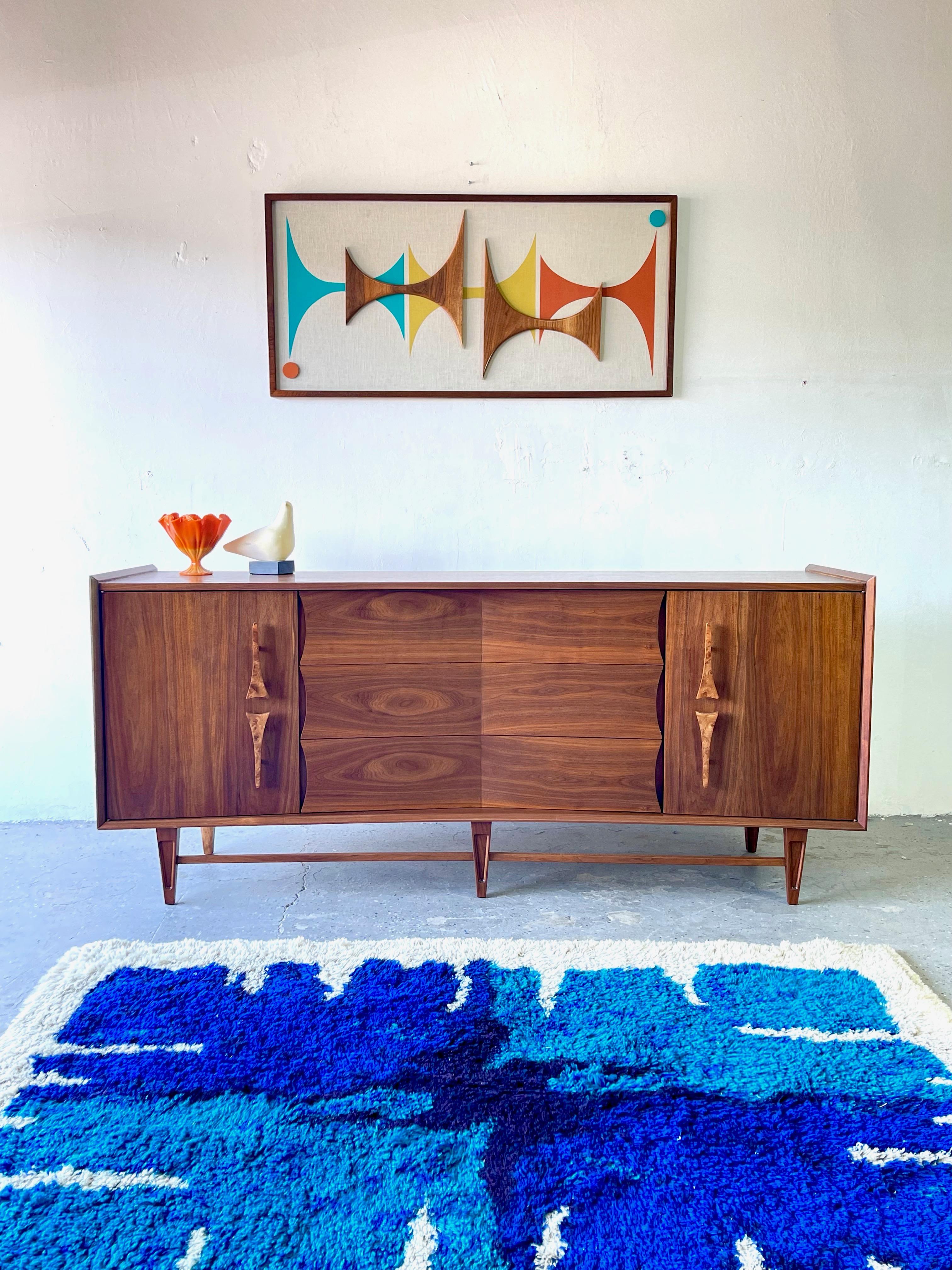 Midcentury sculptural dresser or credenza Kagan Style
An unbelievably cool and designed by the Genova Furniture Company. This mid century modern credenza / dresser featuring gorgeous carved/ Burl wood sculpted wood handles! It features a bow front