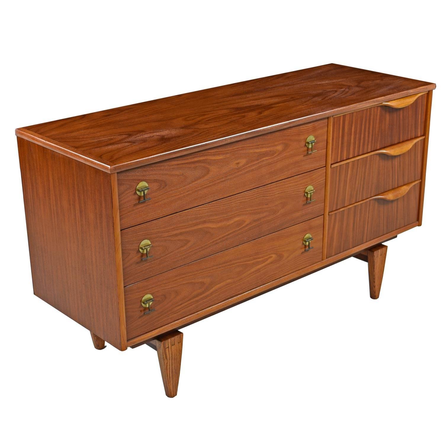 This stunning Mid-Century Modern credenza or dresser was created by Stanley in the 1960s. Lovely design details such as sculptural lipped pulls, breathtaking wood grains and tapered legs celebrate the time period beautifully. The structure and