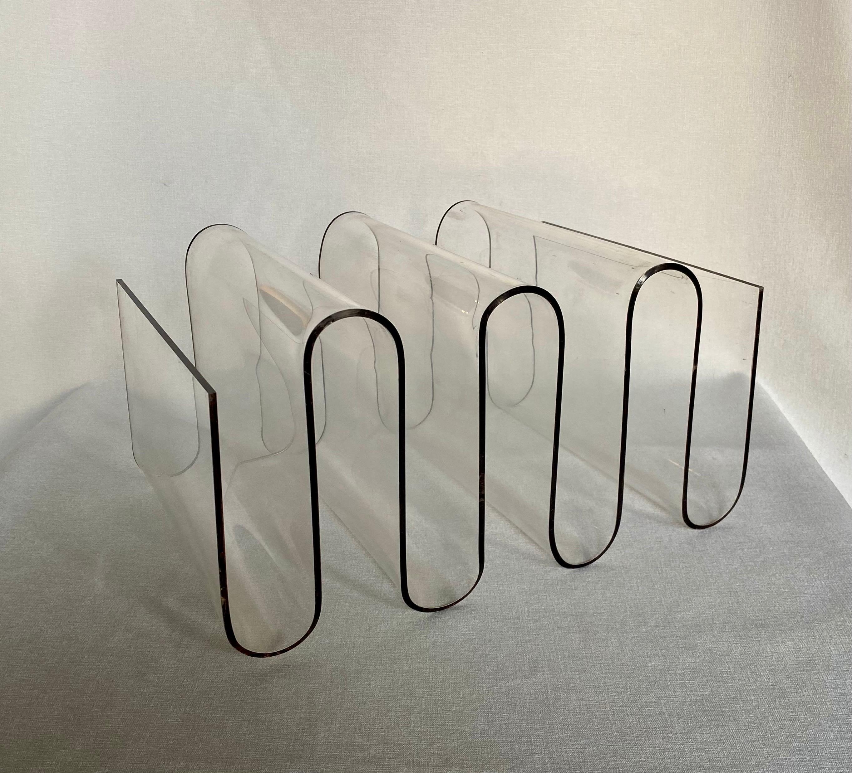 Fabulous Mid Century Modern sculptural Lucite magazine holder. This very unique magazine rack features a curved zigzag wave design.