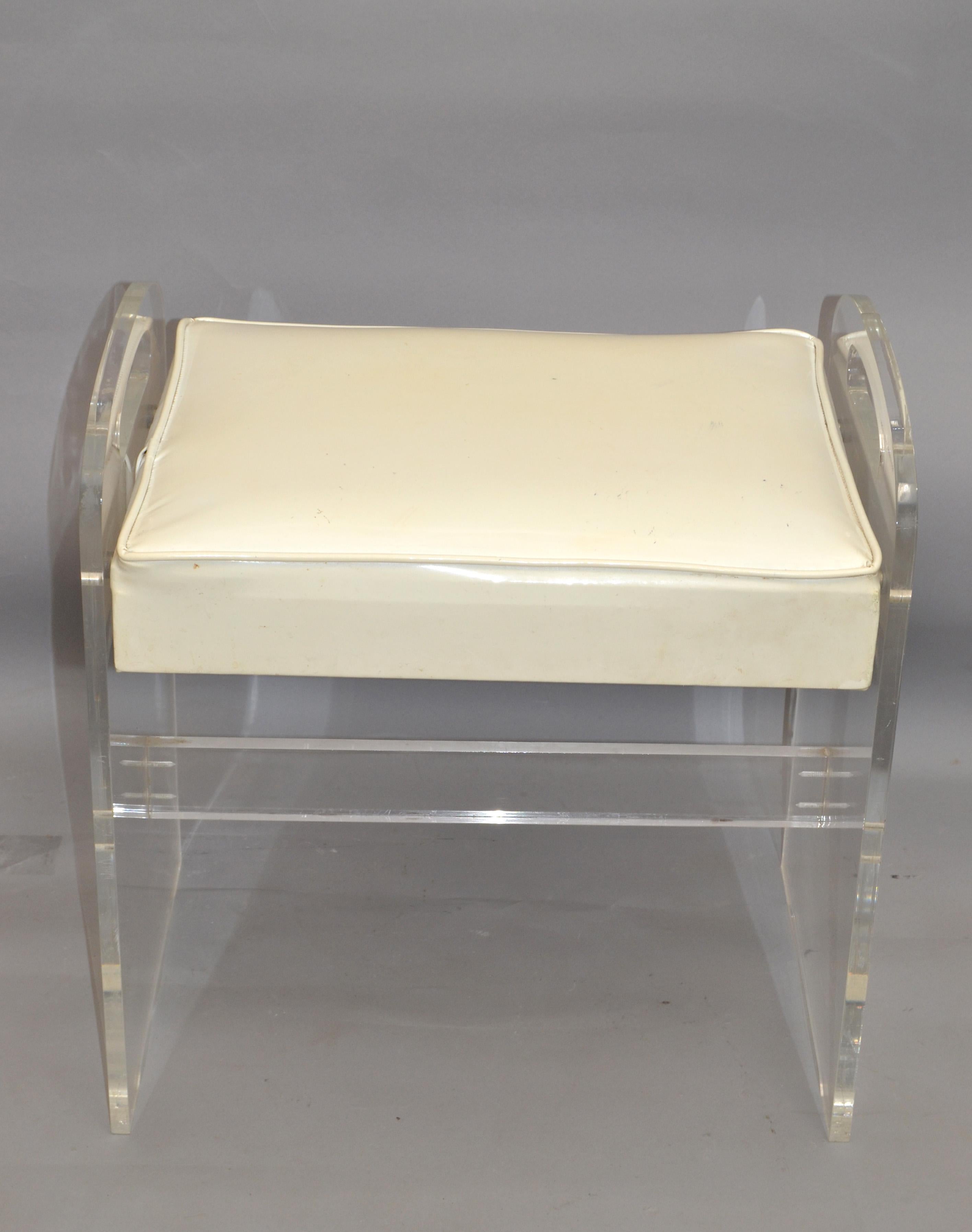 Sculptural Mid-Century Modern Lucite stool in off white vinyl seat and two handles.
This stool can be used as a footstool, vanity stool or a place to put your magazine.
Note the interesting base.
