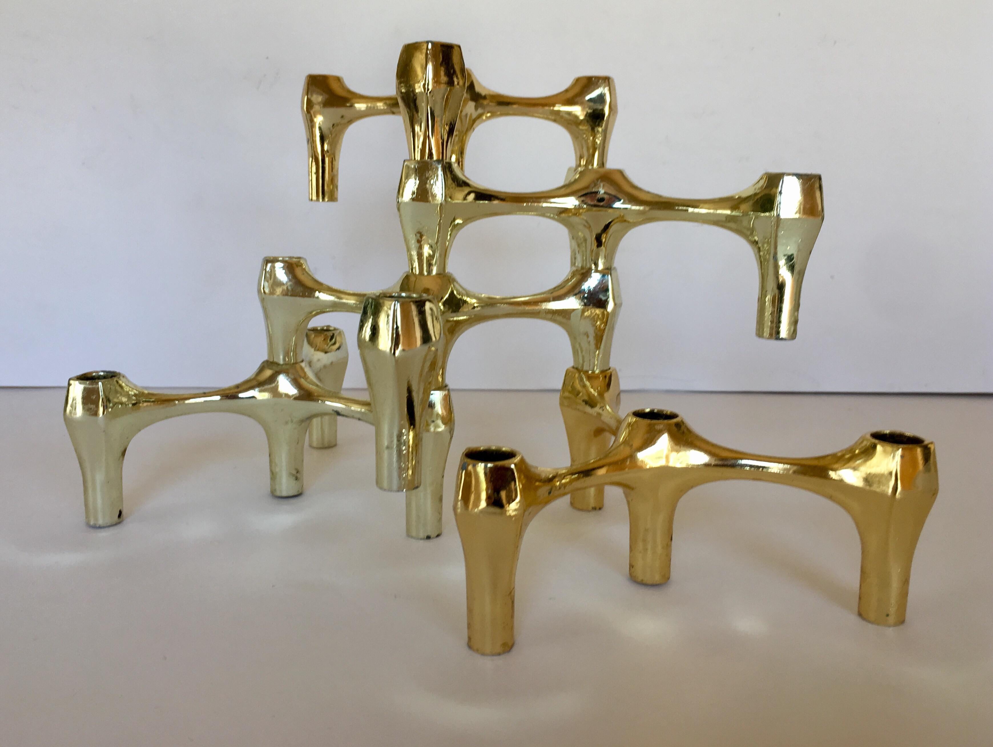 A set of five Mid-Century Modern Fritz Nagel style lacquered brass stacking candleholder sculptures. An iconic mid-20th century design that can be stacked and displayed in countless configurations. A fabulous and unique abstract form tabletop