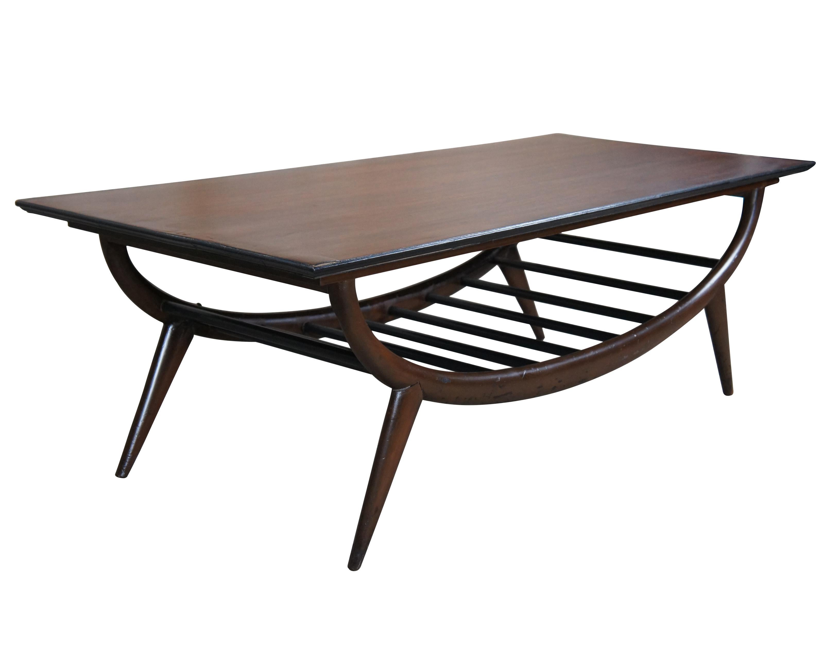An impressive Mid Century Modern coffee table. Features a sculptural oak form with an open slatted base and tapered peg legs. Marked along underside 20529. 54
