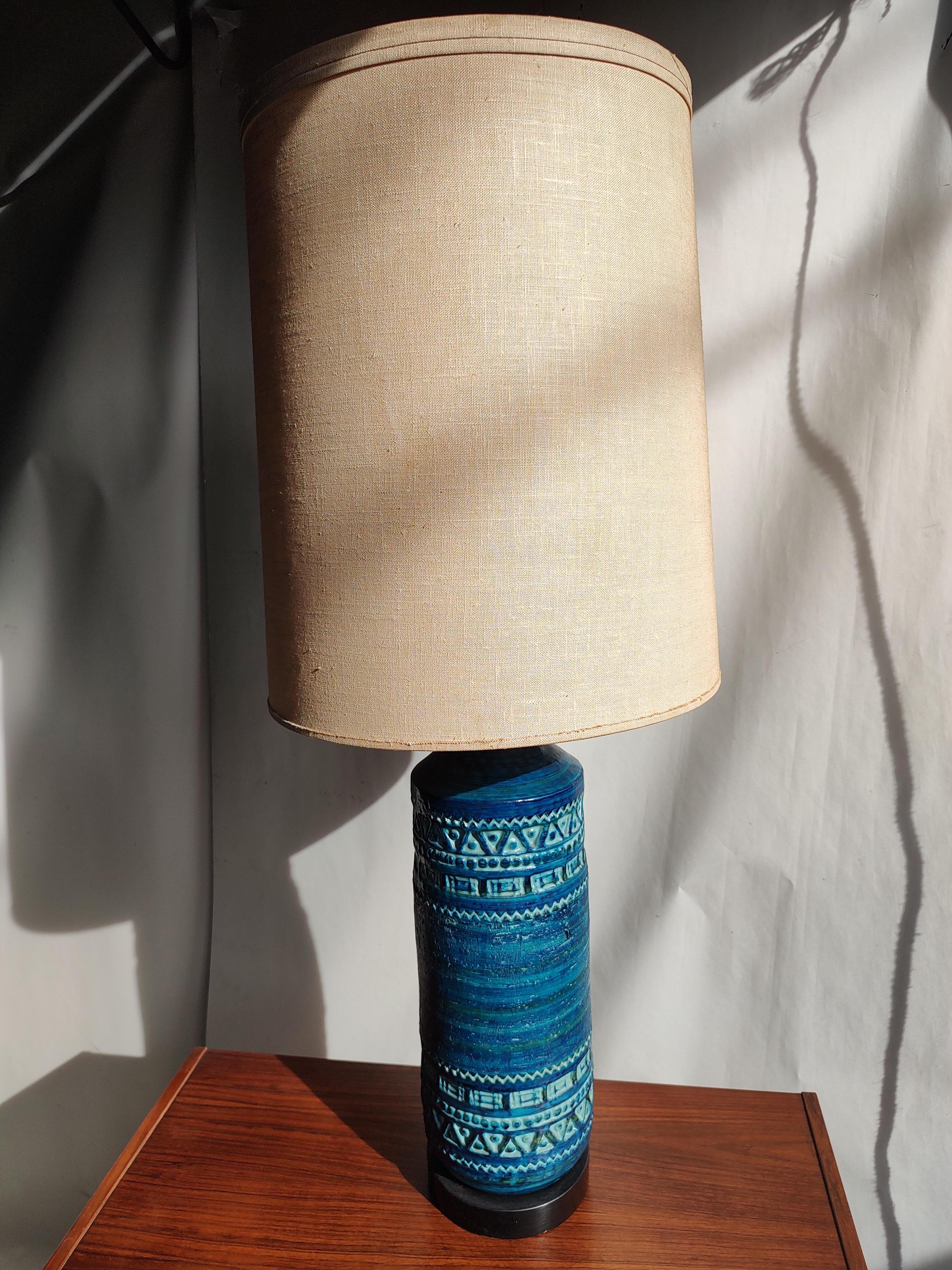 Fabulous and in excellent condition with the correct size lamp shade. Stunning Rimini Blue such a serene color with mid century impressions in the pottery. A beautiful sculpted lamp. Shade is in good condition. Wiring is sound. Hgt to top of socket
