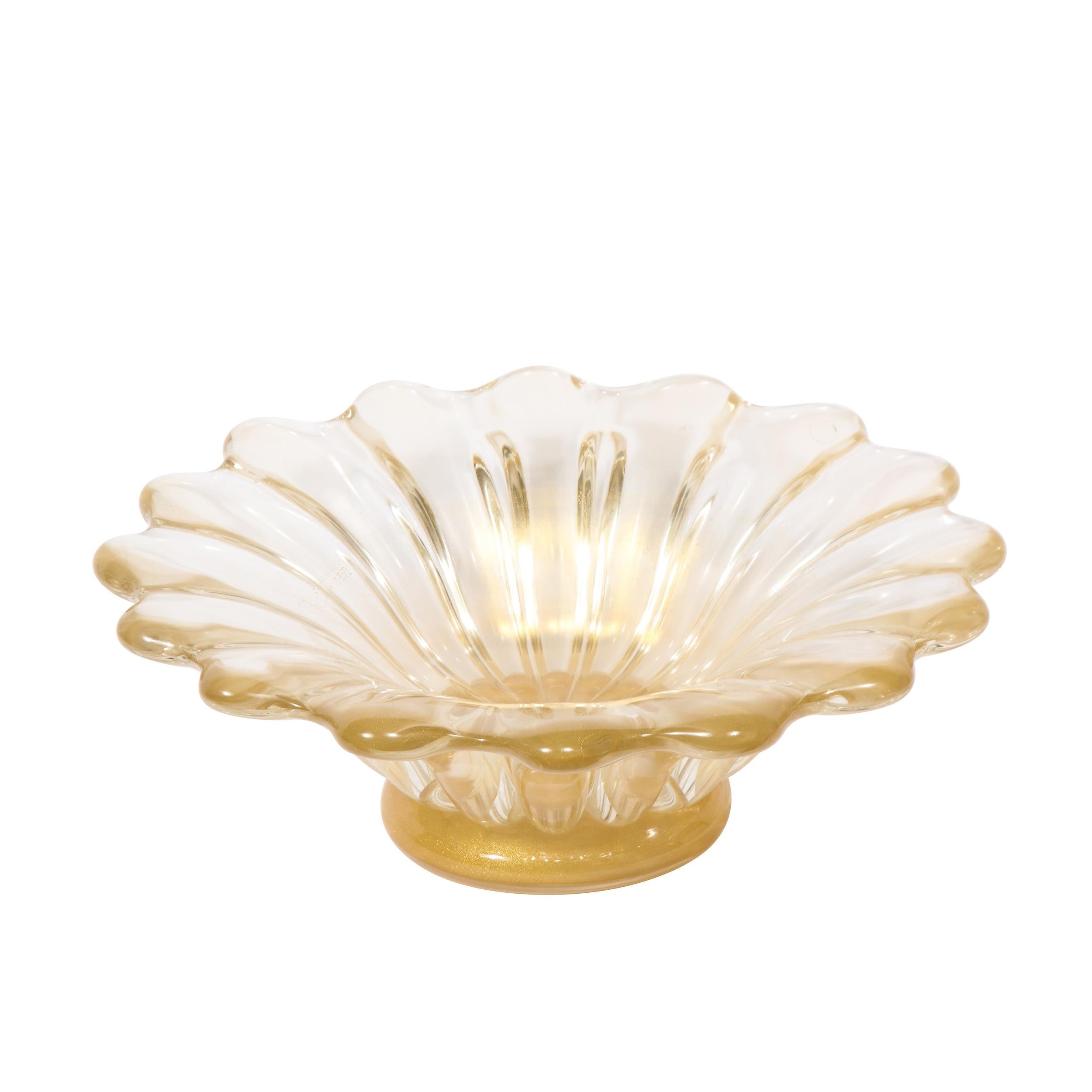 This elegant Mid-Century Modern bowl was realized in Murano, Italy- the island off the coast of Venice renowned for centuries for its superlative glass production- circa 1950. It features a graphic silhouette with a scalloped border in translucent