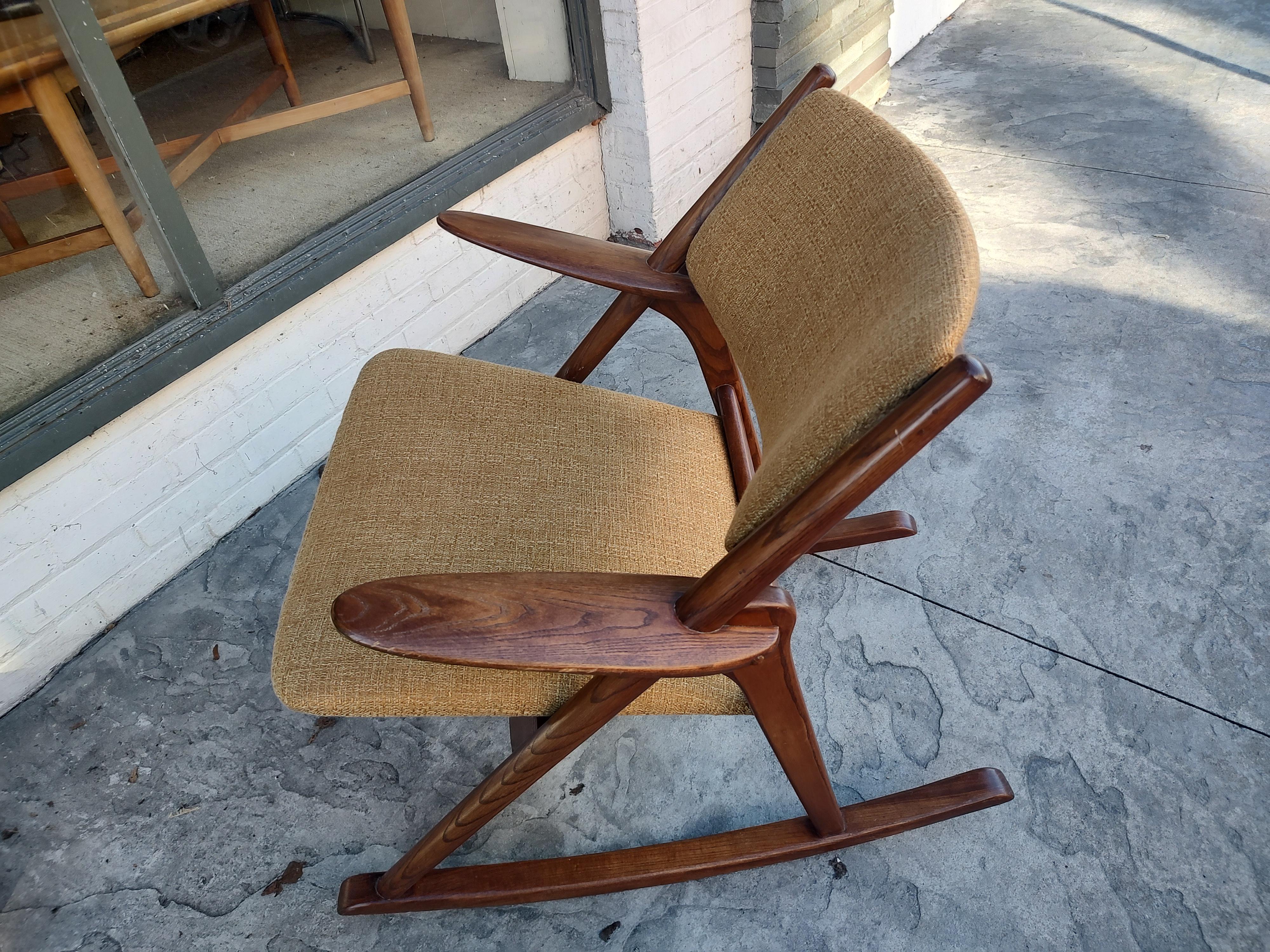 Fabulous teak rocker attributed to Frank Reenskaug with a generous seating area newly reupholstered. Beautiful and wide sculpted paddle arms along with an A Frame design set this rocker apart. Very comfy too! In excellent vintage condition with