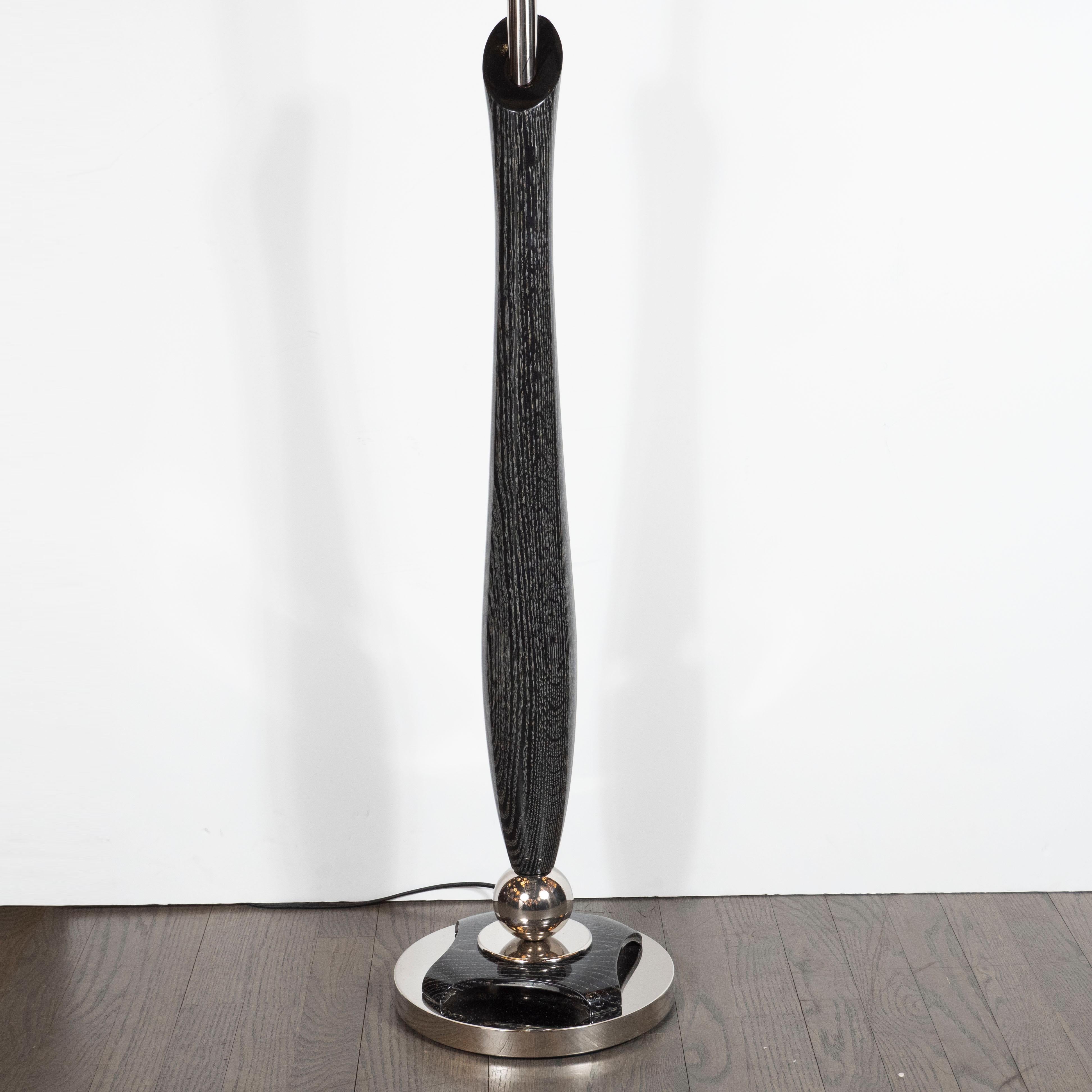 Cet élégant lampadaire de style Mid-Century Modern a été réalisé aux États-Unis, vers 1950. Il présente un corps sculptural en céramique argentée avec une tige en aluminium brossé qui part du centre. La base ronde en aluminium est munie d'un