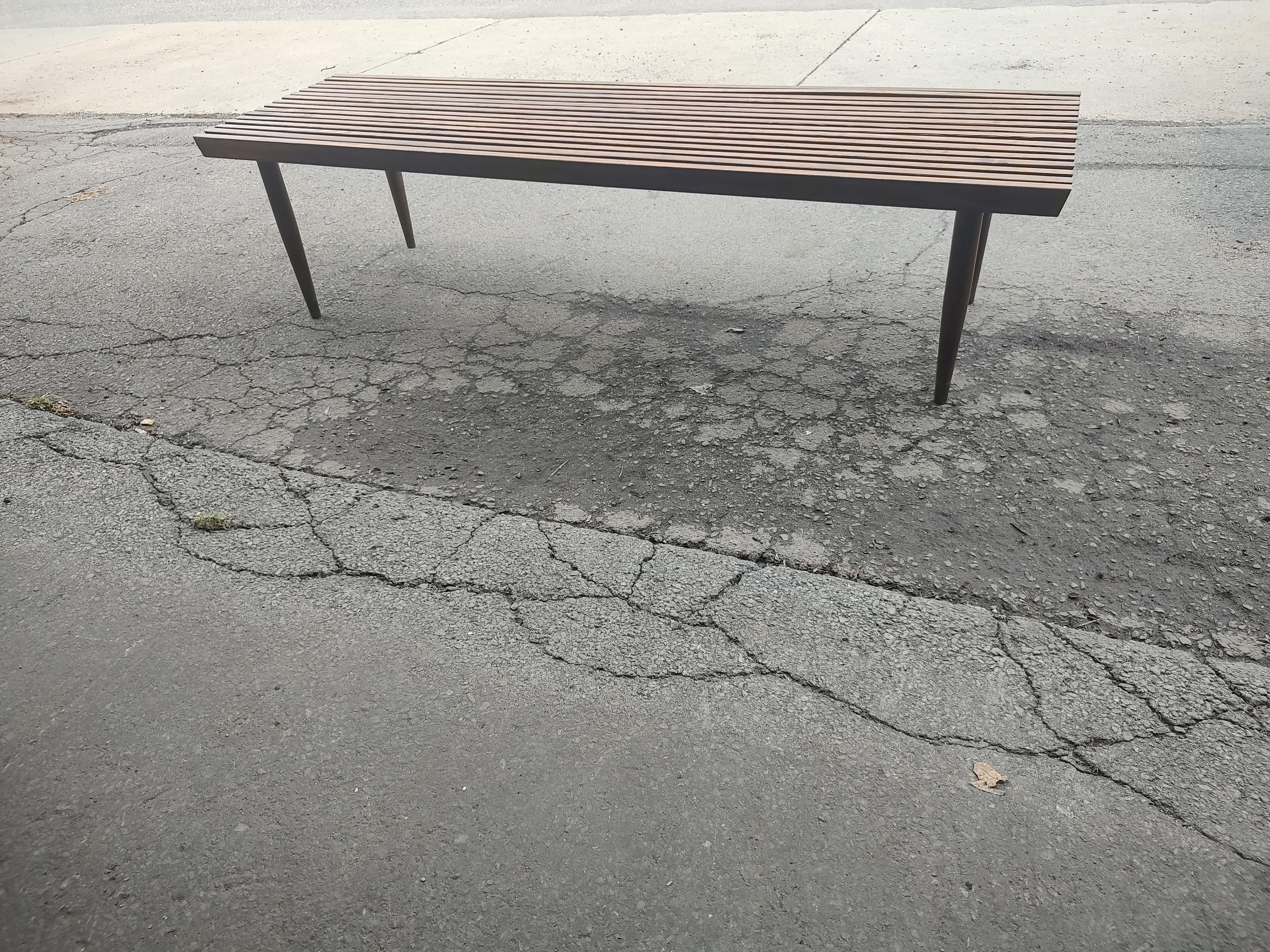 Fabulous slatted cocktail table and or low bench, possibly at the foot of the bed. Wood looks to be pine or for, very decorative graining color. Tapered legs with brass sabots. Tight and sturdy. Legs unscrew for easy transport.