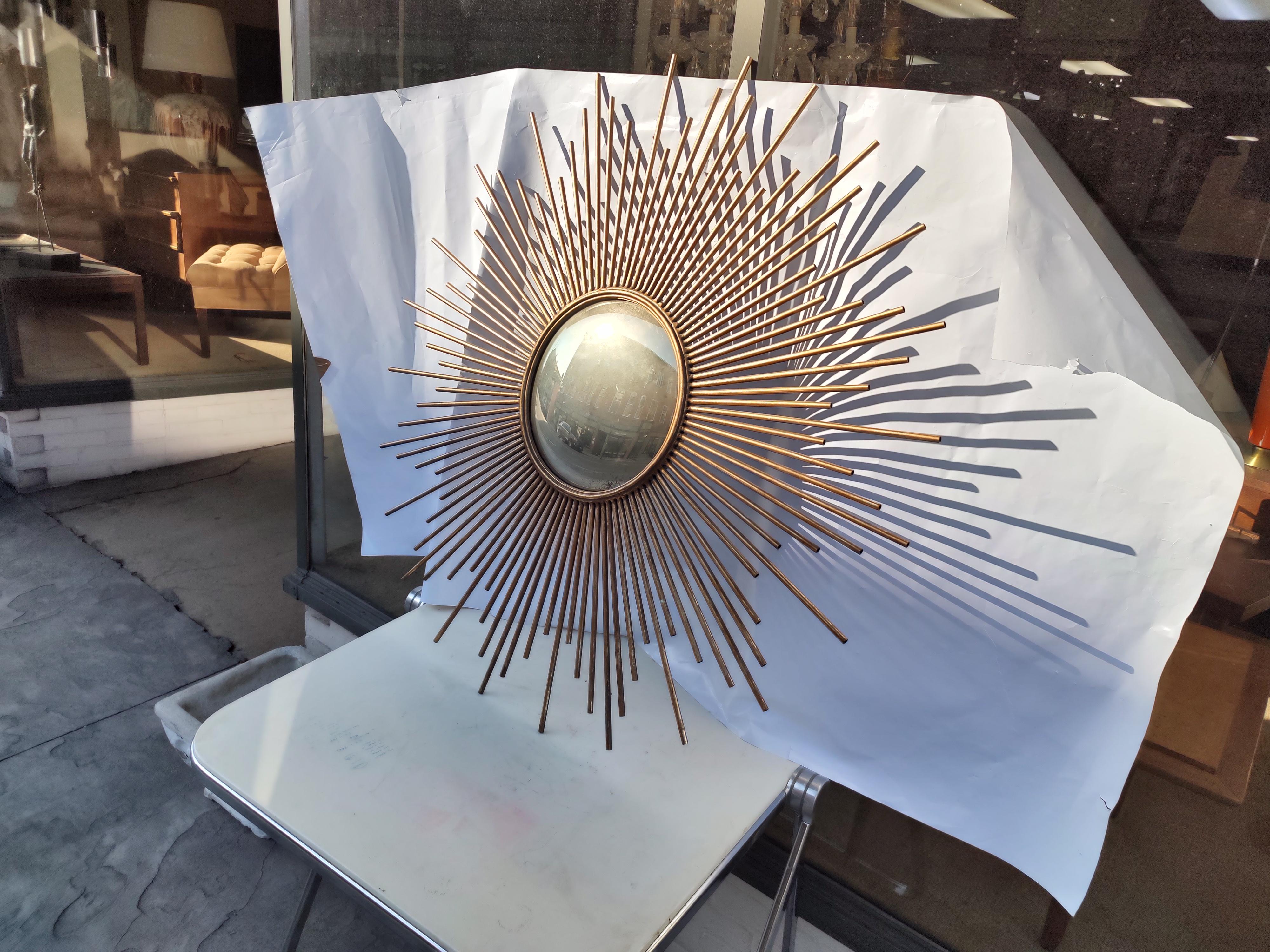 Fabulous gilt iron starburst mirror. Mirror itself is 11 inch in diameter, while the total is 40 inch. In excellent vintage condition with minimal wear. Has a new piece of luan on the back for protection. Quality workmanship all welds are tight.