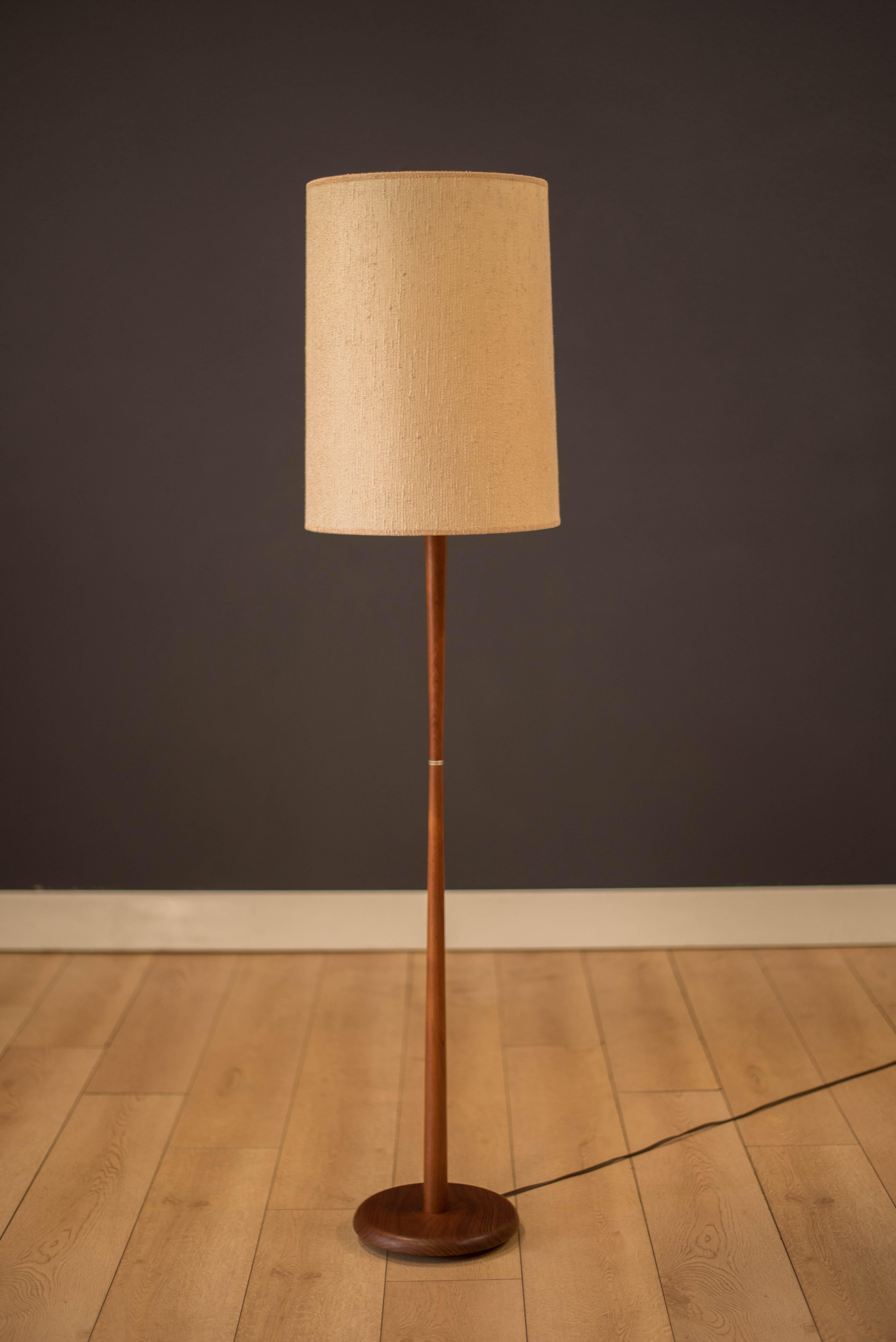 Vintage sculptural floor lamp in teak, circa 1960s. This unique piece features aluminum ring accents equipped with a three-way switch mechanism. The shade is not included. 
 