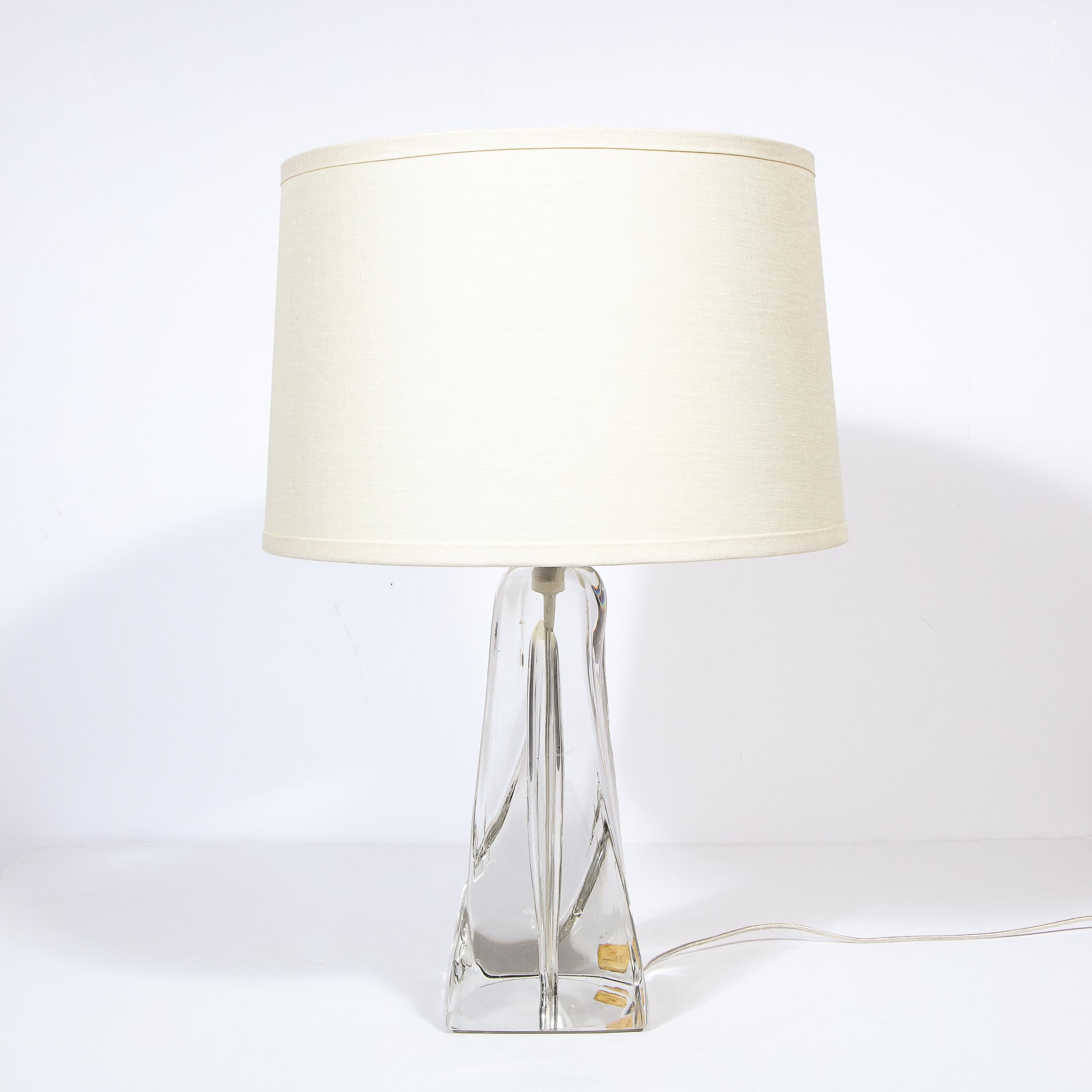 This stunning and sculptural Mid-Century Modern table lamp was realized by the legendary atelier of Daum, circa 1960, in the town of Nancy, France. The piece features an abstracted, amorphic conical form with a wealth of rivulets and rounded