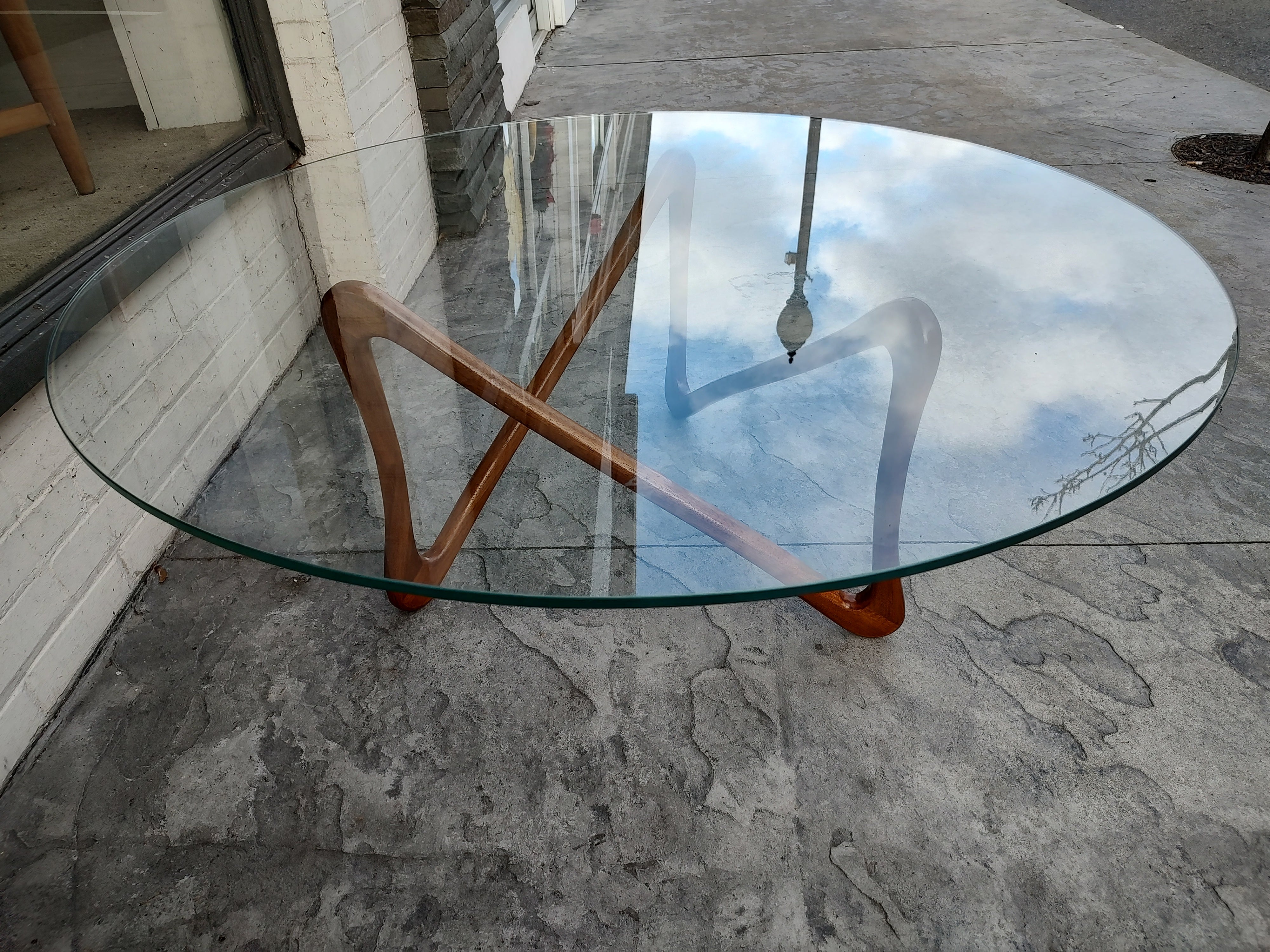 Fabulous sculpted walnut base with a large dimensional glass top. Beautiful creation in a rare form. In excellent vintage condition with minimal wear. Very tight frame.