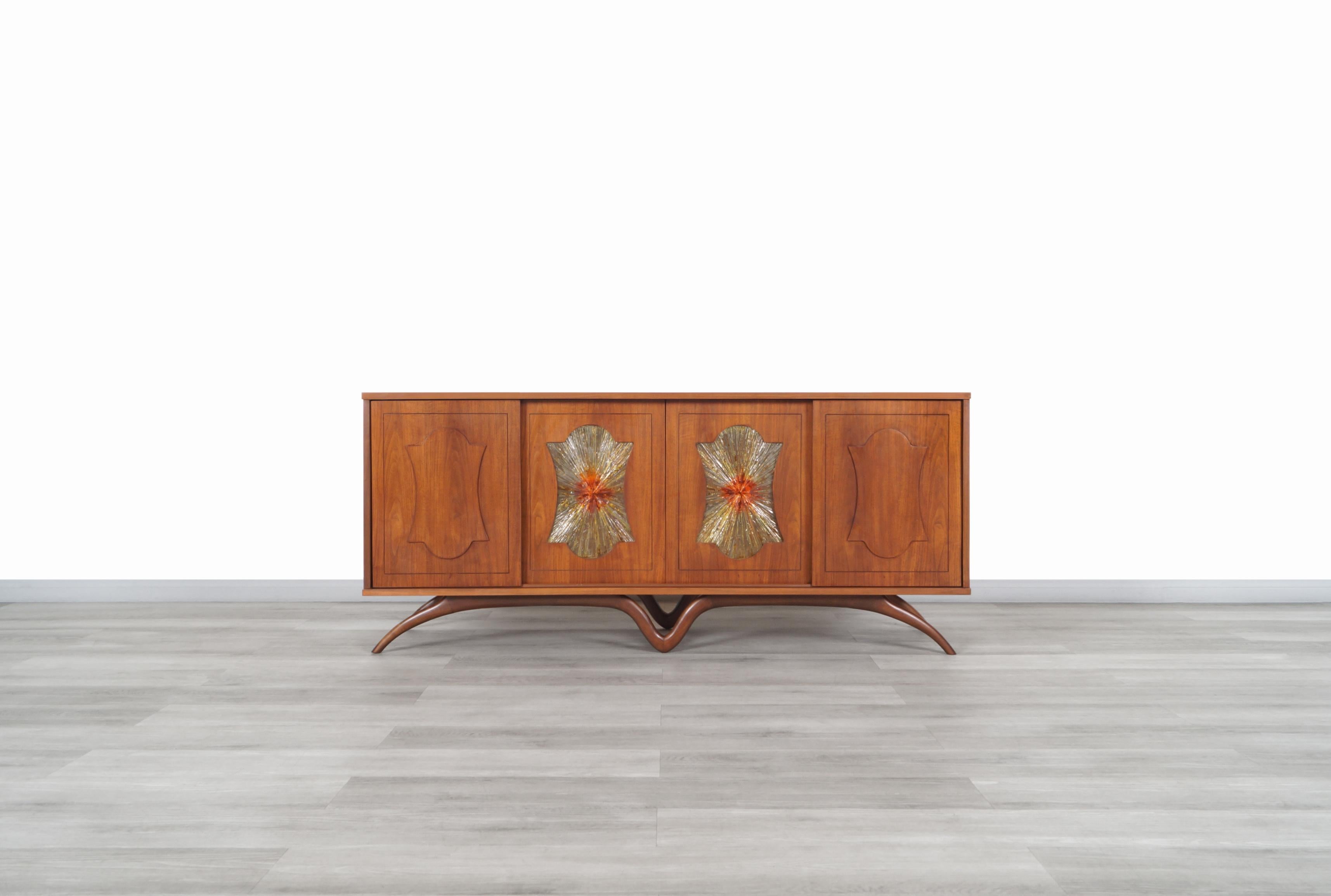 Wonderful mid century sculptural walnut credenza manufactured and designed in the United States, circa 1950s. This credenza has an elegant design where the details in its construction make it different from any other piece of furniture. It has been