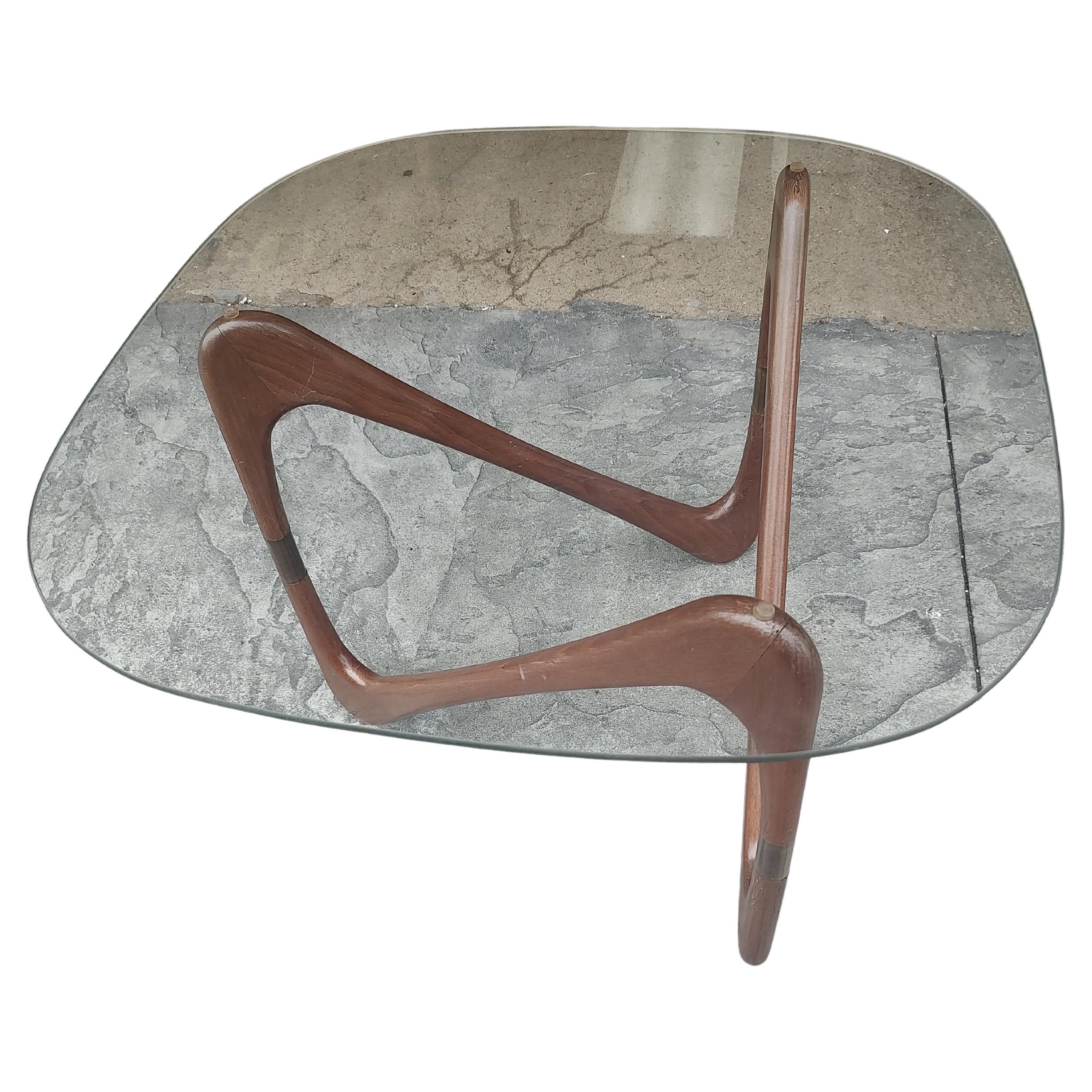 Design insolito con curve in noce e stile boomerang. Anelli in legno di noce collegati tra loro da montanti in ottone. Piano in vetro quadrato 24,75 x 20h. Il vetro è perfetto. Il legno presenta alcuni segni di usura dovuti all'età.