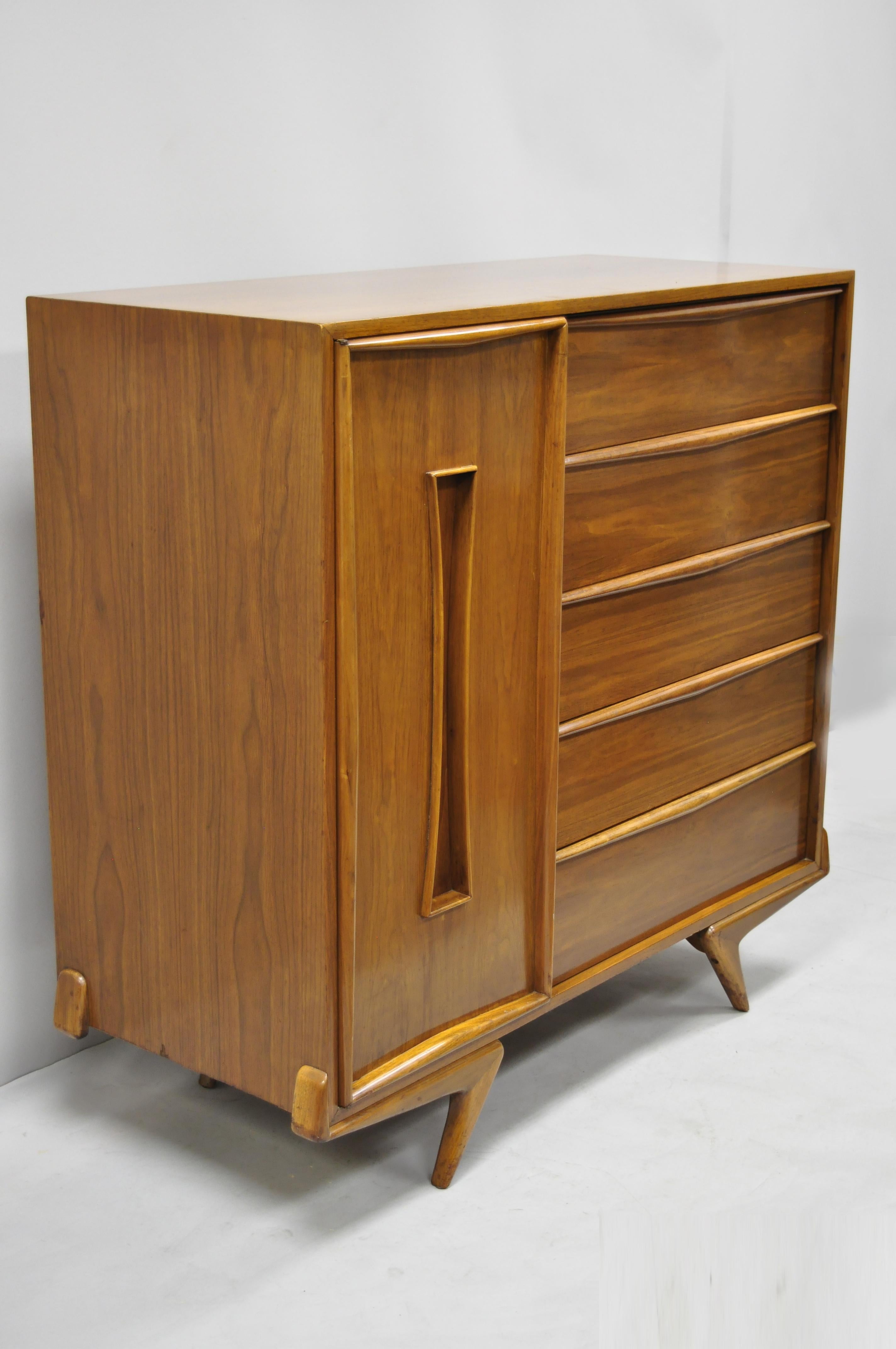 Vintage Mid-Century Modern sculptural walnut gentlemen’s tall chest dresser with sculptural boomerang legs. Item features angled and tapered 