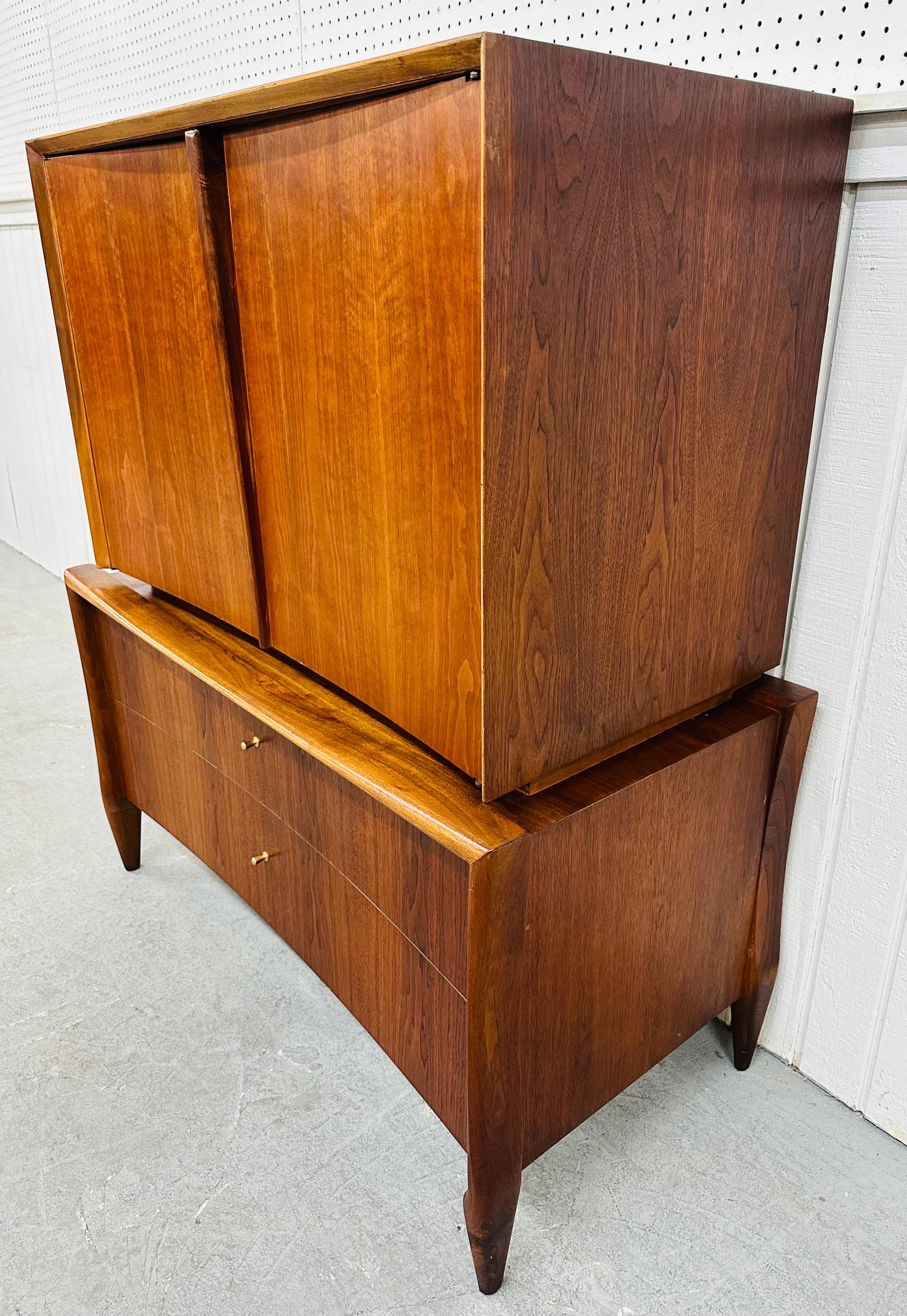 This listing is for a Mid-Century Modern Sculptural Walnut Gentlemen’s Chest. Featuring a straight line chest on chest design, two doors at the top that open up to three hidden drawers, two larger drawers at the bottom with original hardware,