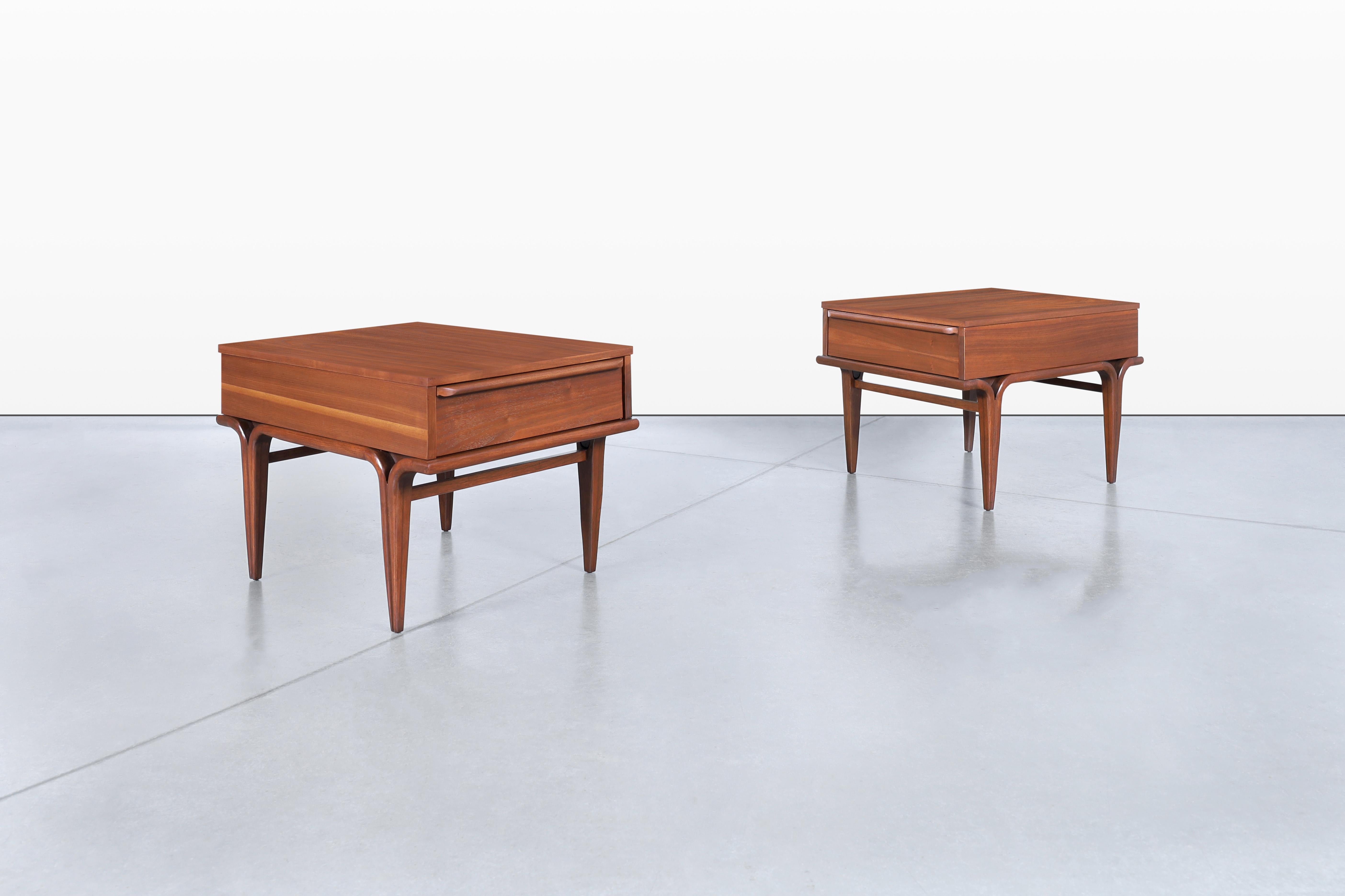 These amazing vintage walnut nightstands/side tables are a true testament to American craftsmanship from the 1960s. Each piece features a spacious pull-out drawer, adorned with original handcrafted handles that reflect their unique character. The