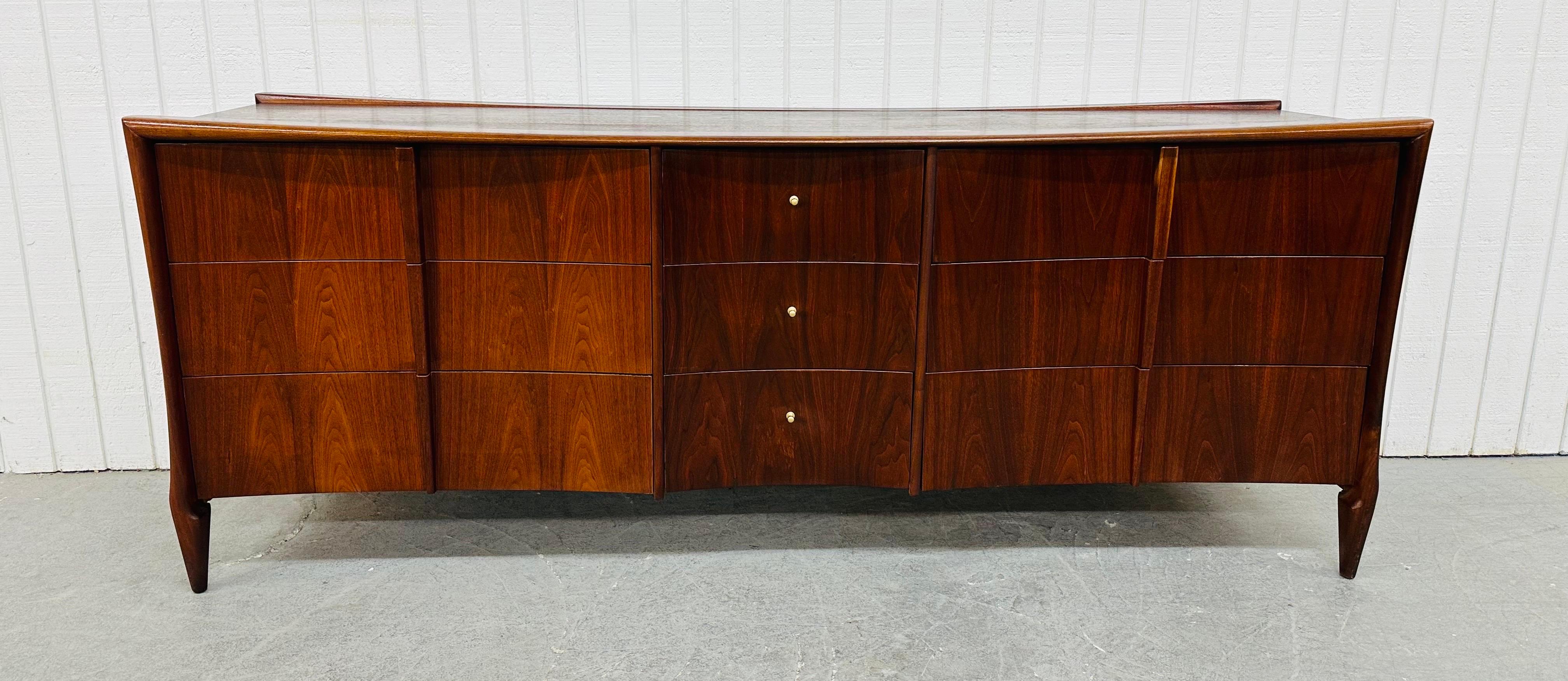 This listing is for a Mid-Century Modern Sculptural Walnut Triple Dresser. Featuring a straight line design, three large drawers on each end with sculpted wood pulls, three smaller drawers in the center with original brass hardware, sculpted modern