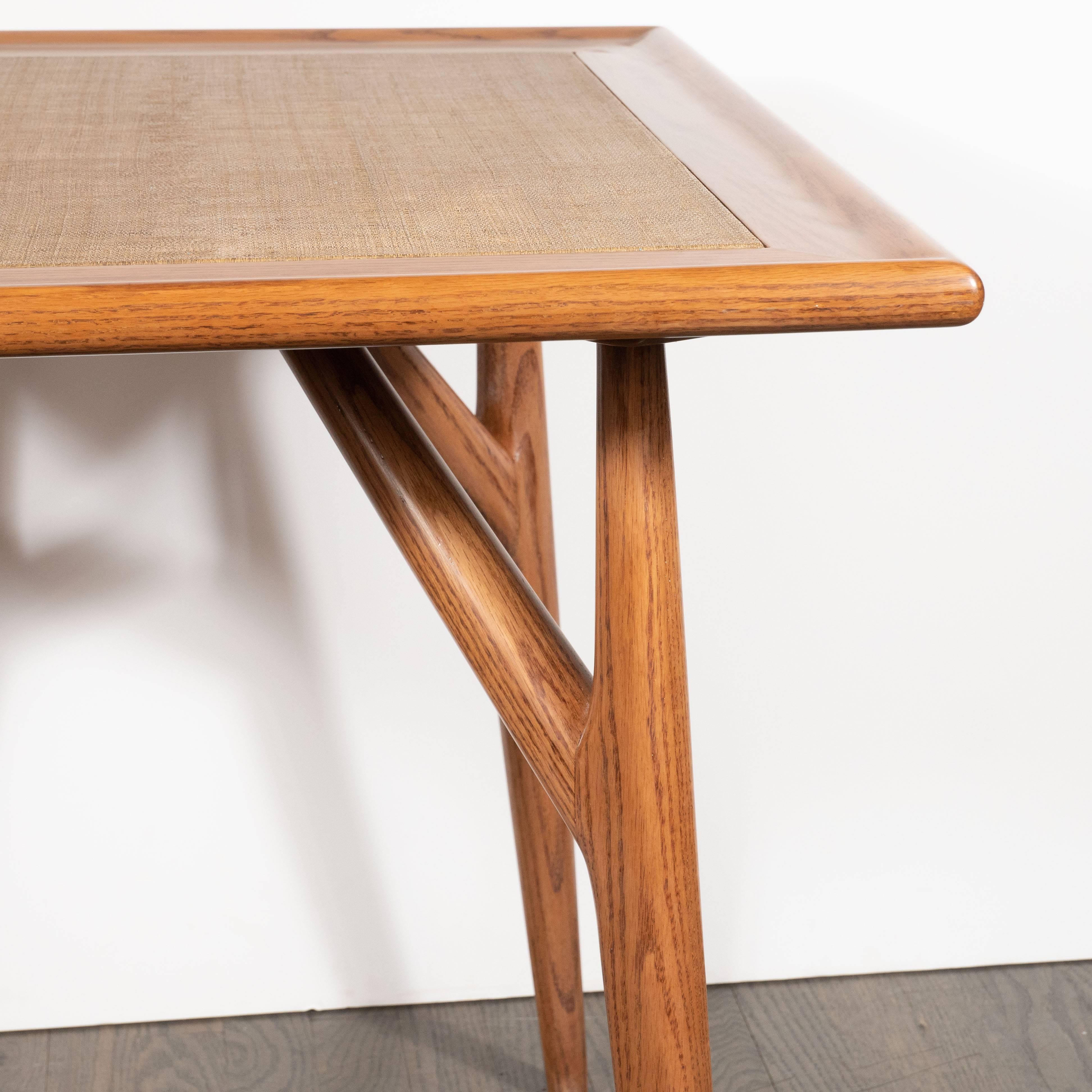 This stunning sculptural and sophisticated table was realized in the United States, circa 1960. It features conical legs adjoined at roughly a 60 degree angle by a support all in white oak. The center of the table has been wrapped in linen in an