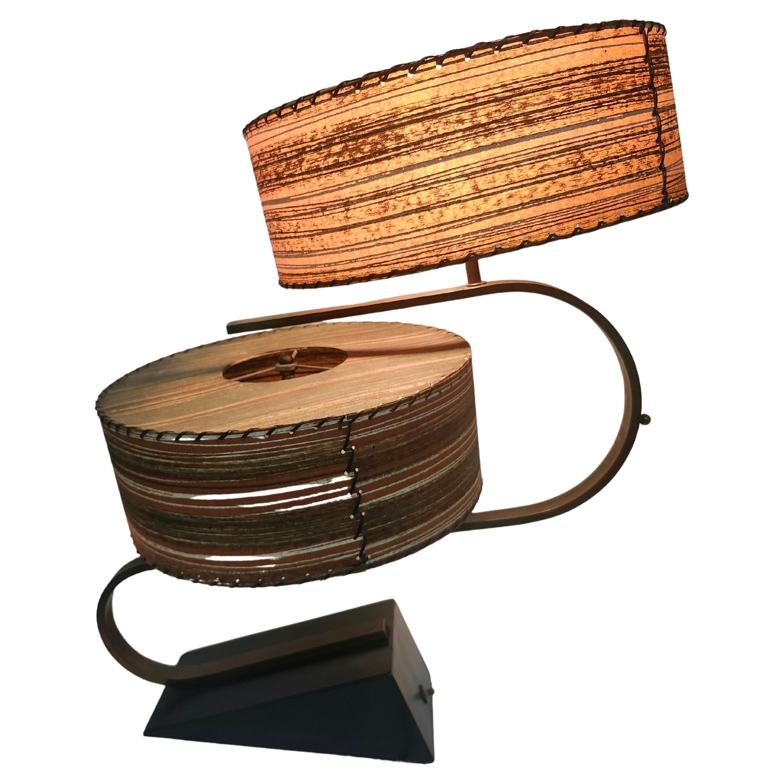 Spectacular Zee lamp by the Majestic lamp co. with twin fiberglass tamborine shades. Wood base in black lacquer with brass tubing all in excellent vintage condition from age and use. Two tiny punctures on the top of one shade, very minor and hard to