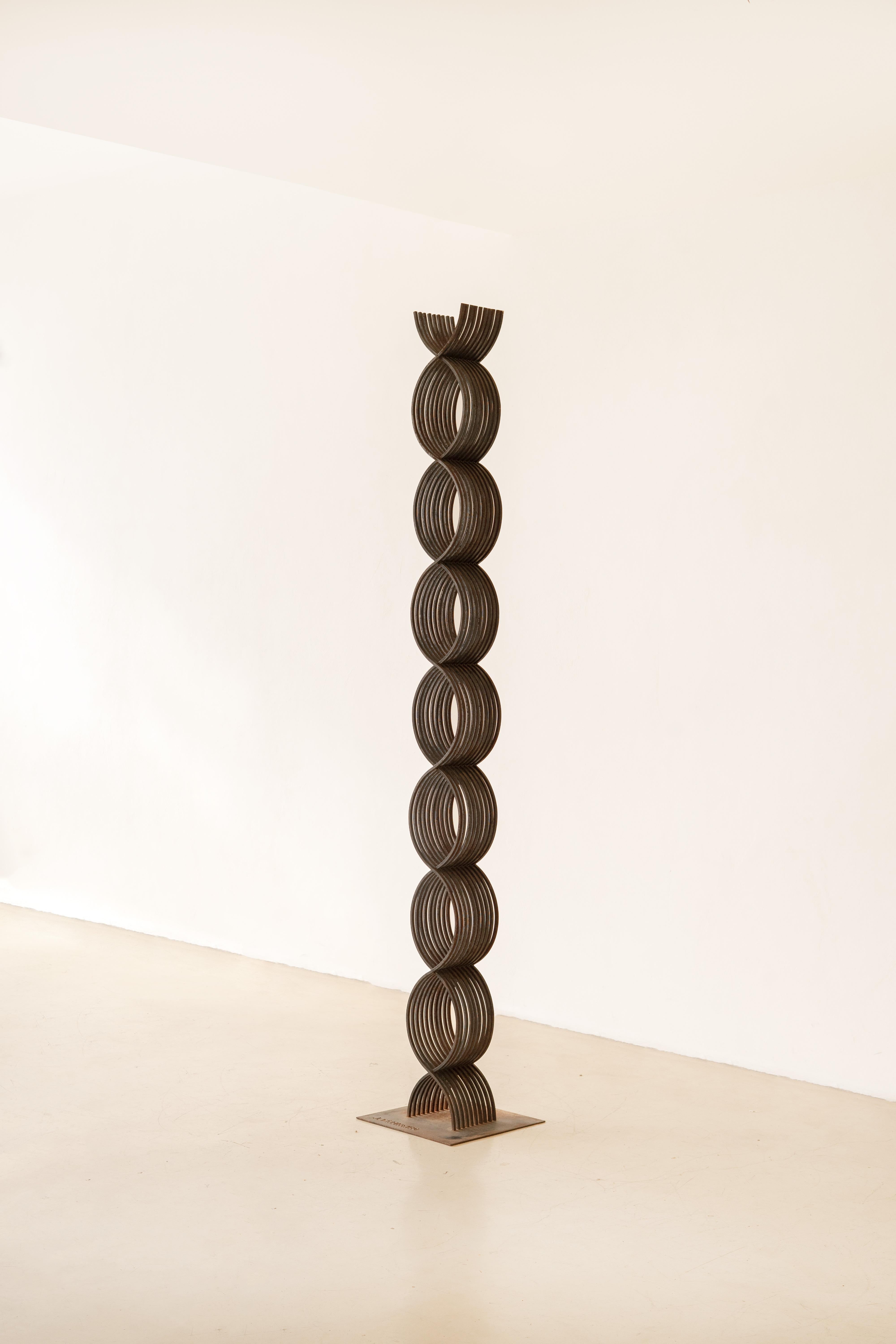 Questa monumentale scultura in ferro di Joaquim Tenreiro è alta 242 cm e si erge da una base quadrata che porta la firma dell'artista. Composto da forme circolari intrecciate, il pezzo rivela la maestria di Tenreiro nell'equilibrio e nelle