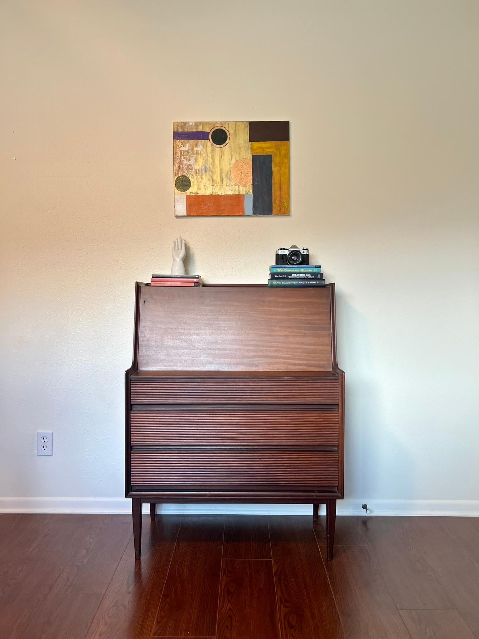 A striking secretary desk by Richard Hornby. A classic piece of mid-century design from one of the best British mid-century designers. Made from Afromosia teak this piece is simple and elegant with 3 front drawers and drop down to showcase the
