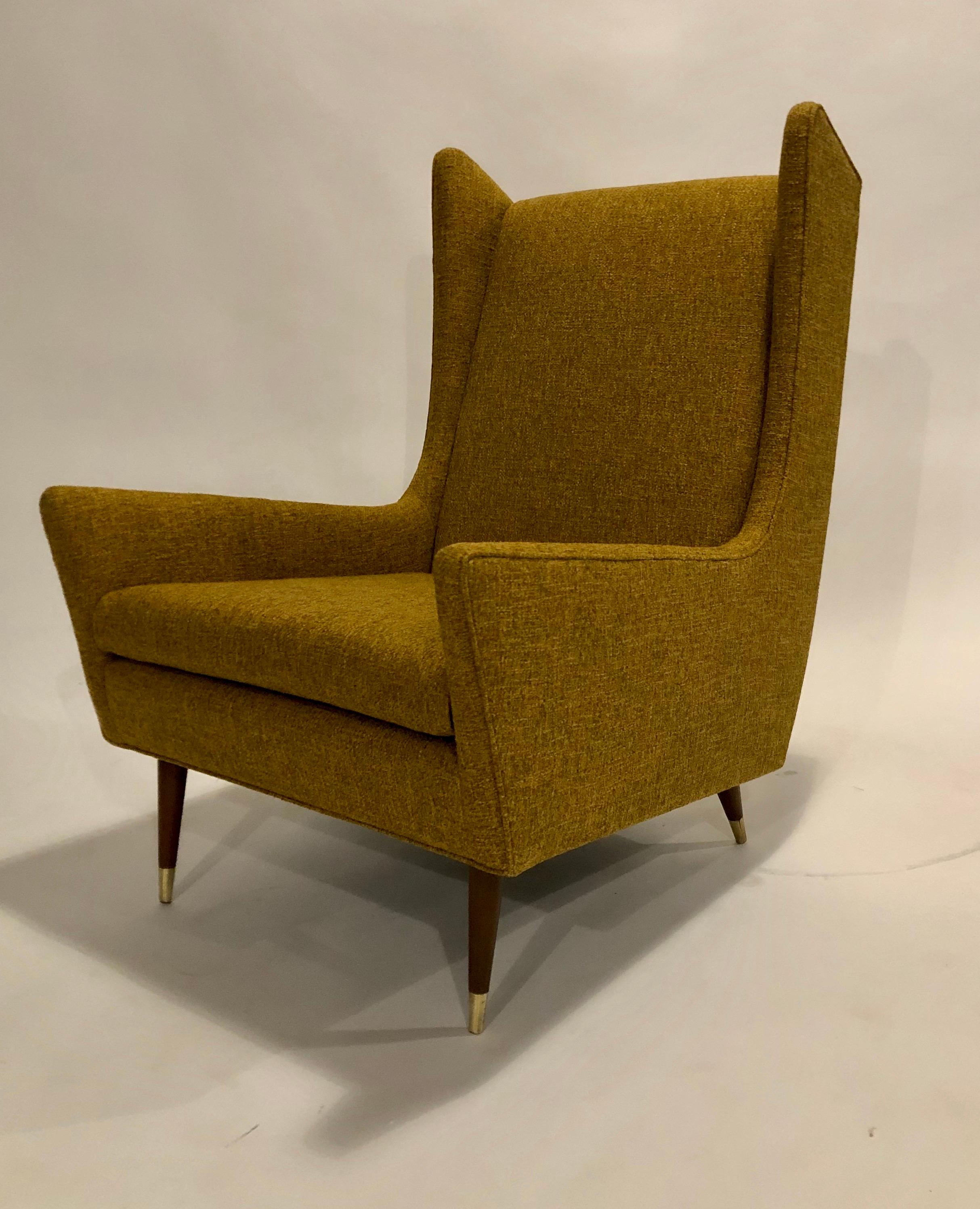 Mid-Century Modern wing chair by Selig newly upholstered in a gold weave WIND Exclusive Design fabric. All new cushions and restored wood and brass caps make this vintage chair showroom condition. Attributed to IB Kofod Larsen.