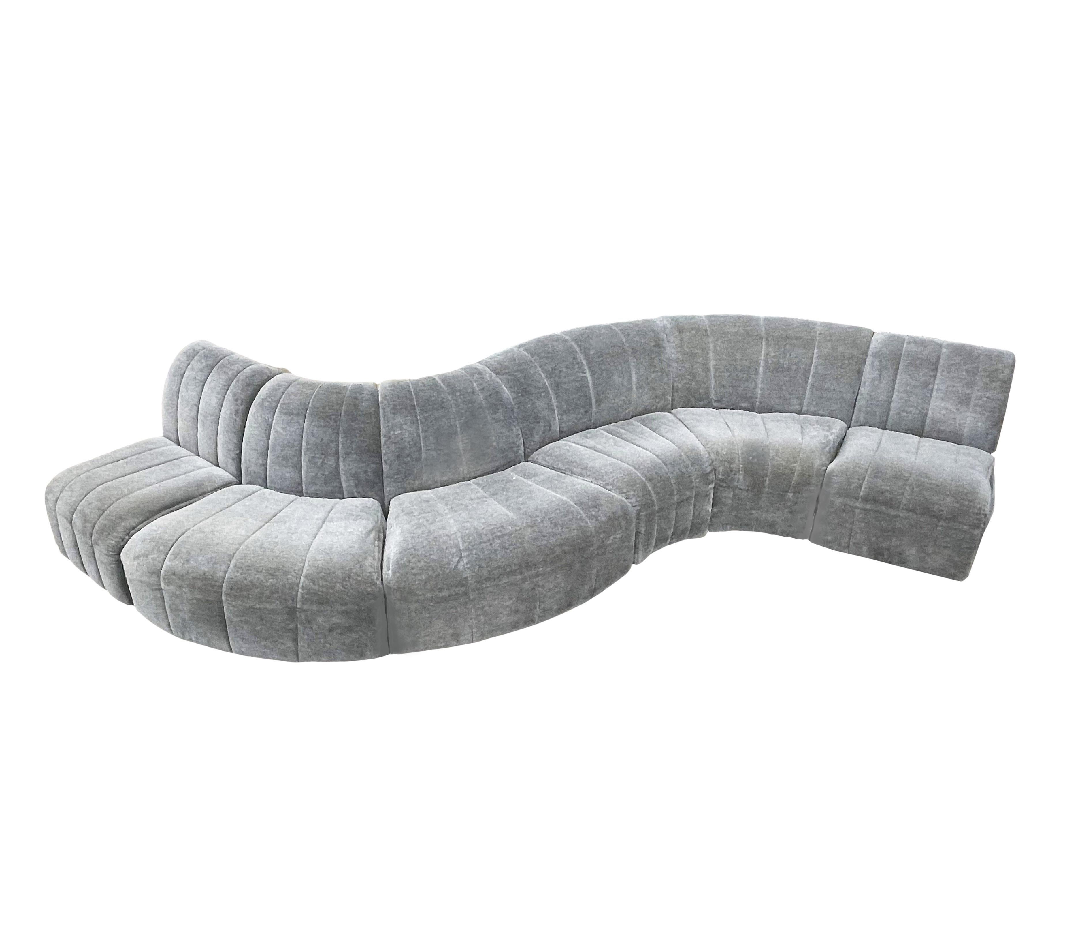 A curvy modular sofa designed by Milo Baughman and produced by Thayer Coggin in the 1960s. It features a six-piece modular design. Fabric is original gray mohair and is tired. Recovering is recommended but can be used as is. Manufacturer label.