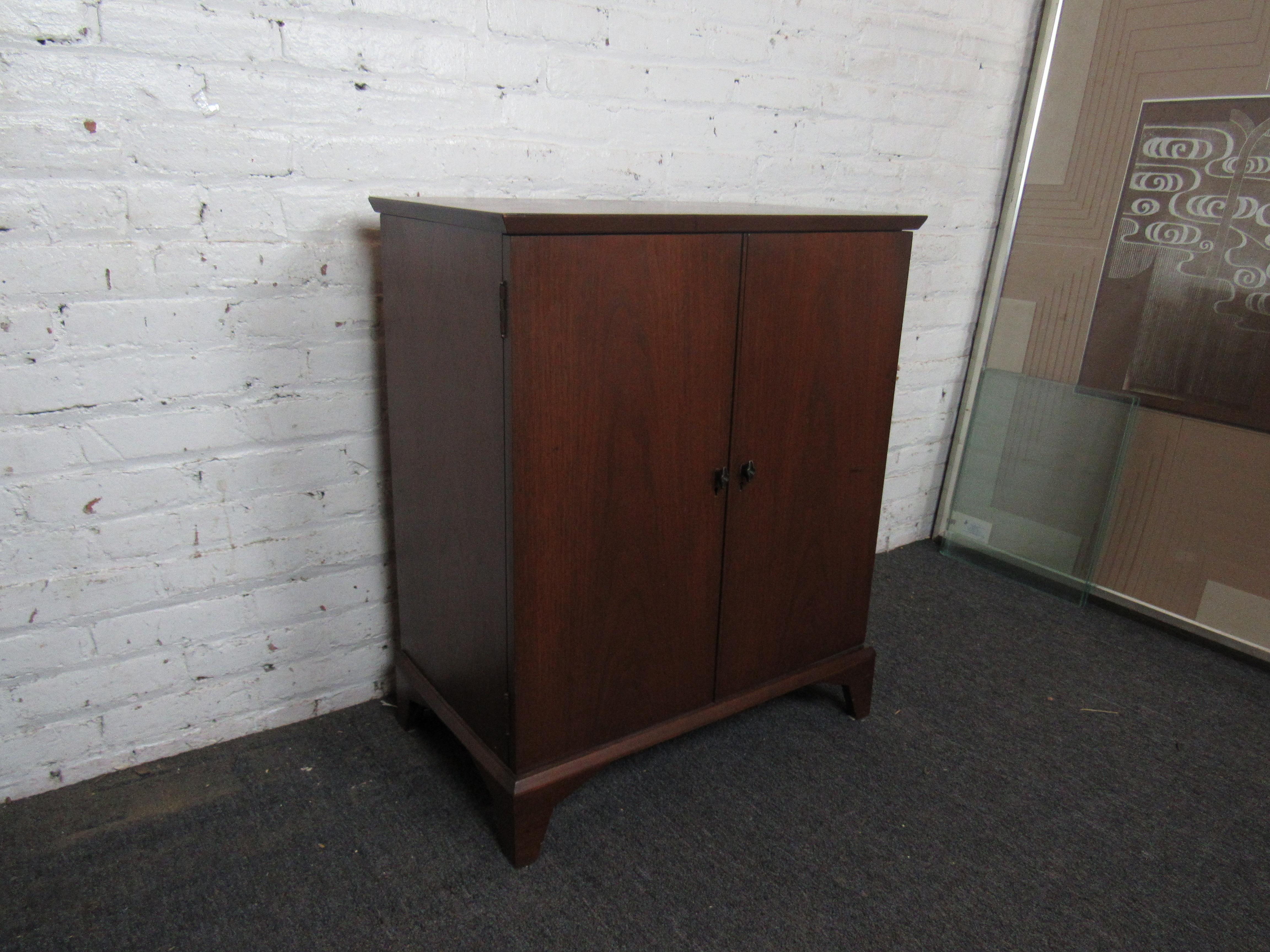 This vintage cabinet offers plenty of storage in a compact design made complete by a handsome walnut exterior. The cabinet's top also opens to reveal a stone surface. Please confirm item location with seller (NY/NJ).