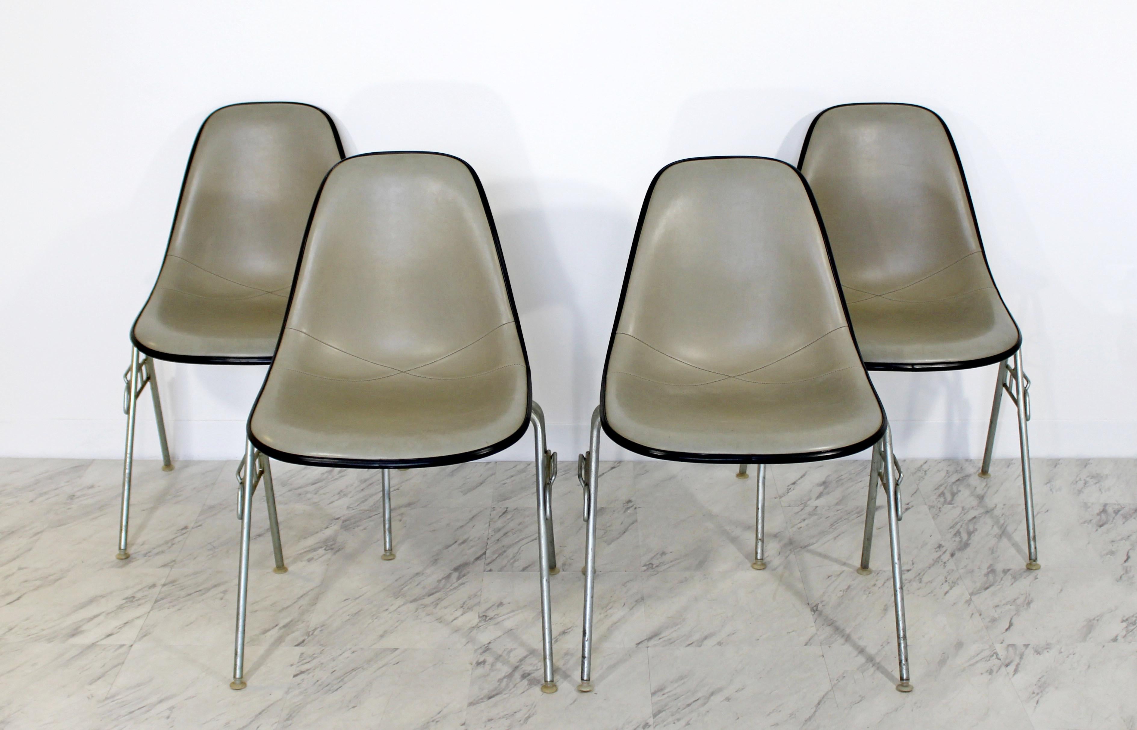 For your consideration is an original set of four, DSS stackable side chairs, with leather seats on metal bases by Charles & Ray Eames for Herman Miller, circa the 1960s. In very good condition. The dimensions of each are 22
