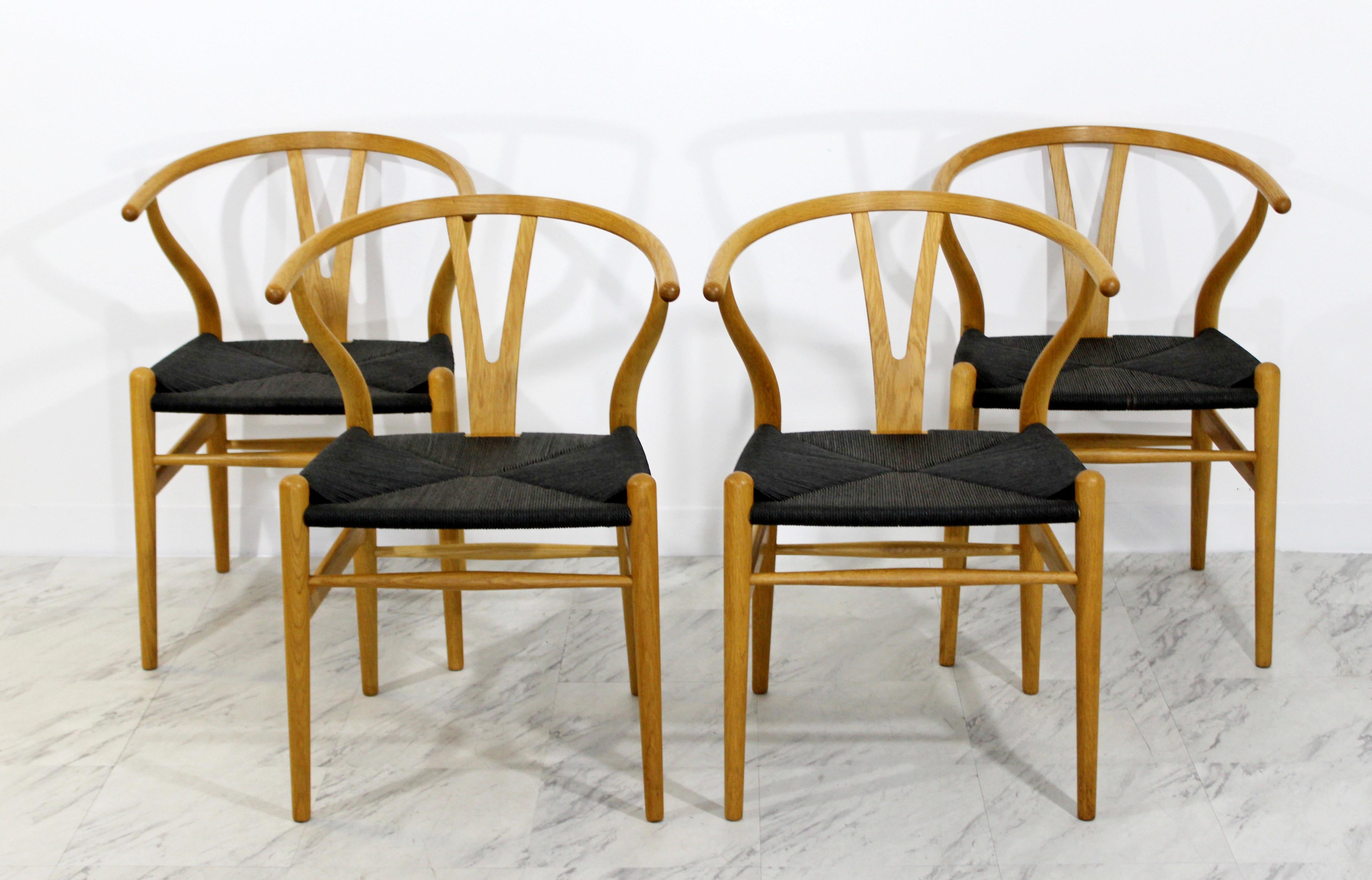 For your consideration is a marvelous, set of four, original, wishbone CH24, dining chairs, made of curved oak and black rush or cord, by Hans Wegner for Carl Hansen, made in Denmark these are the patented newer reproduction . In excellent