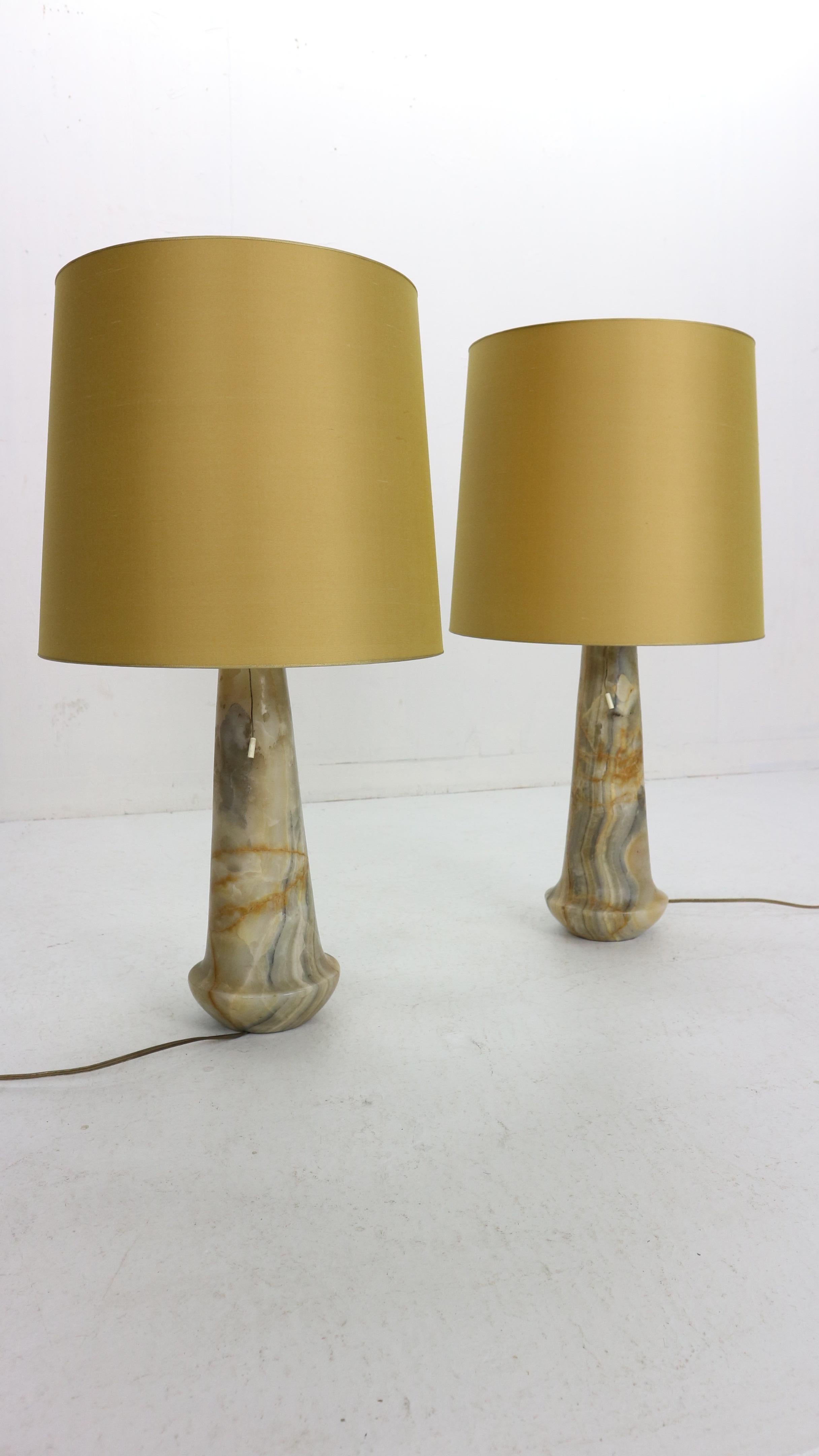 Mid-Century Modern period set of two table lamps manufactured in 1960s period, Italy.
The ovular body base is made of marble witch has beautiful colourful patina and it's in his original condition.
The lamp shades has been newly made of light