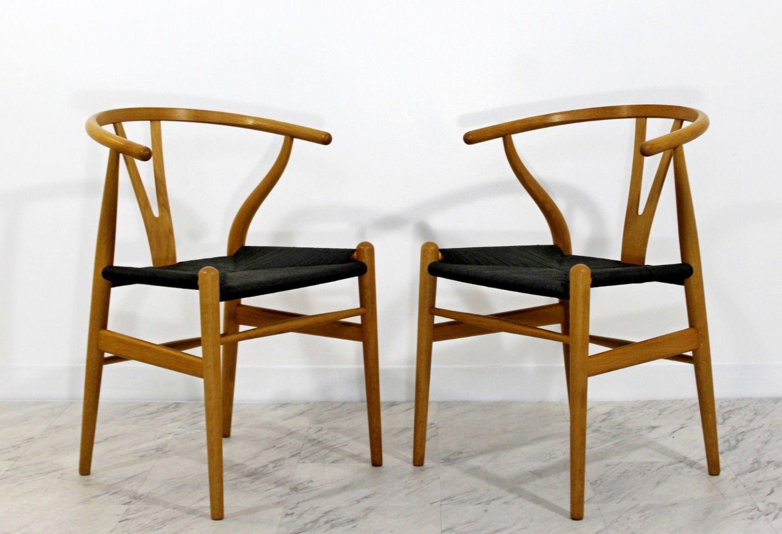 For your consideration is a marvelous, set of 2 original, wishbone CH24, dining chairs, made of curved oak and black rush or cord, by Hans Wegner for Carl Hansen, made in Denmark these are the patented newer reproduction. In excellent condition. The