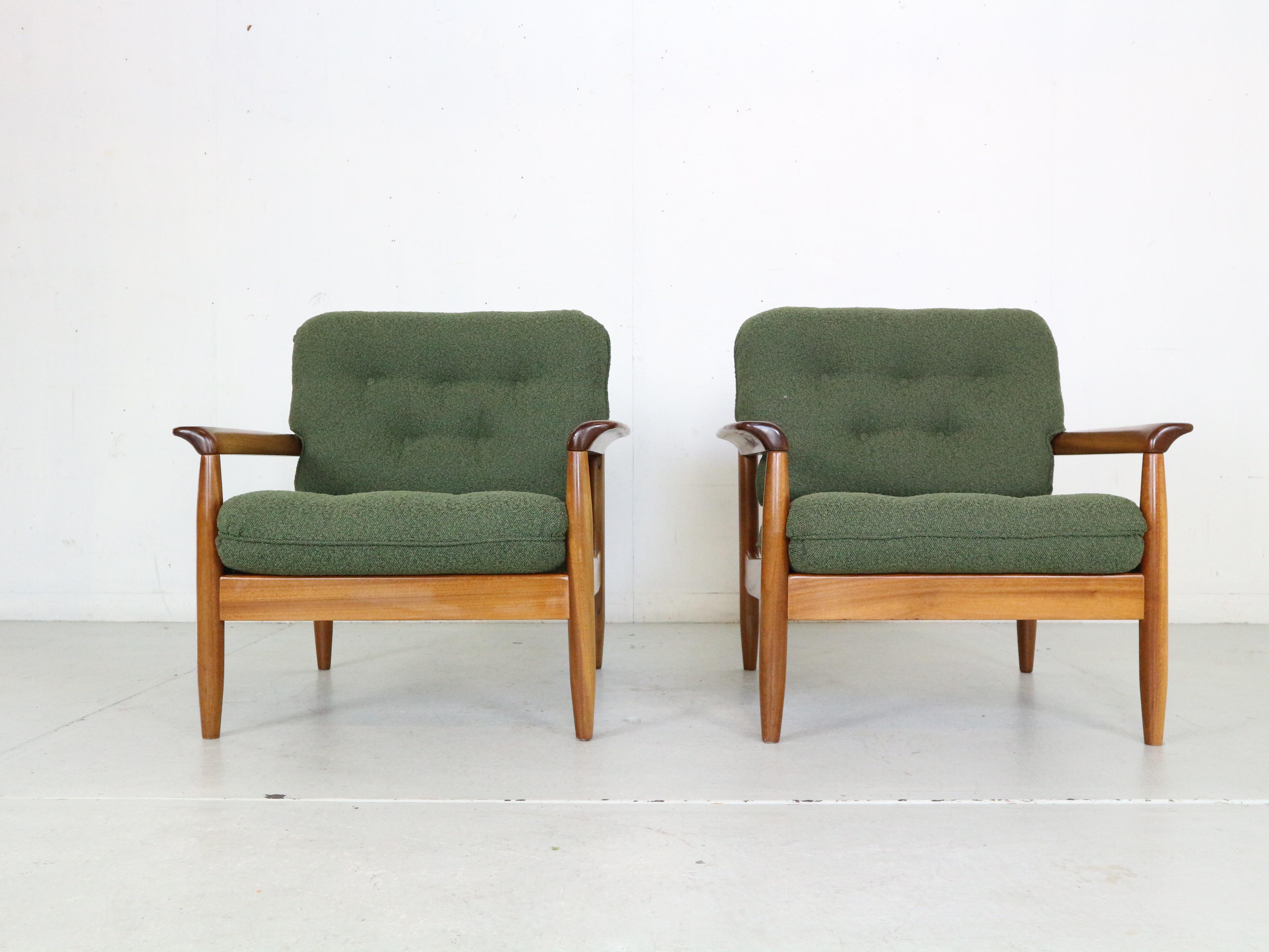 Mid-Century Modern period set of two lounge chairs made in 1960's period, Denmark. 
The frame of the chairs are made of teak wood, with curved armrests and open beautifully shaped back. 
The cushions has been newly reupholstered in green boucle